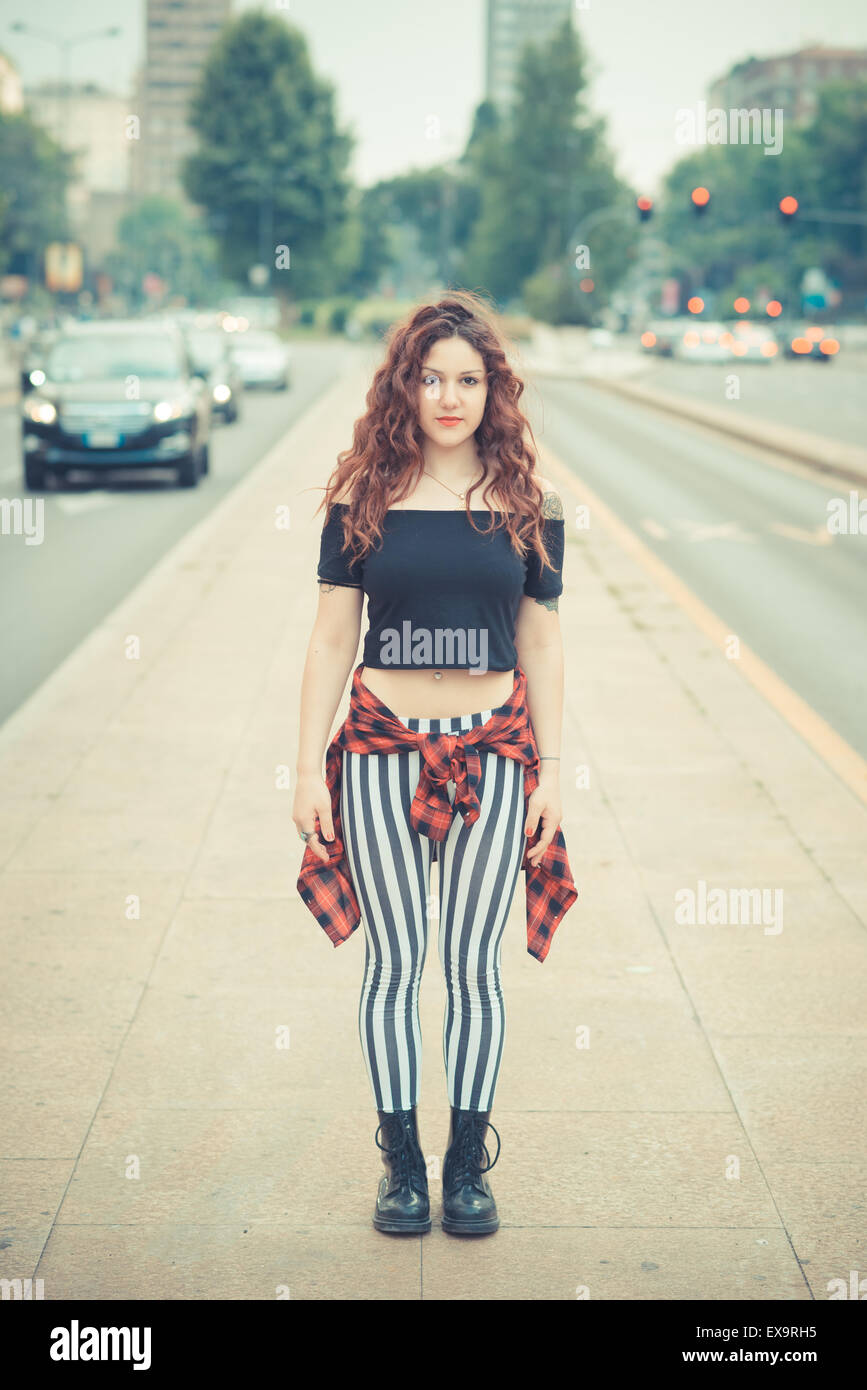 Belle jeune femme hippie avec les cheveux bouclés rouge dans la ville Banque D'Images
