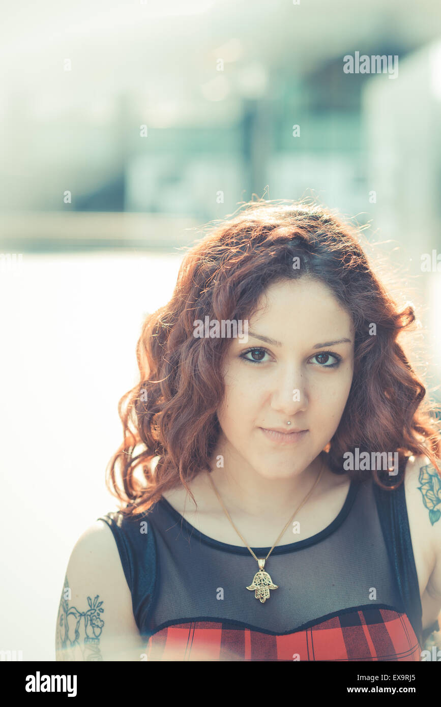 Belle jeune femme hippie avec les cheveux bouclés rouge dans la ville Banque D'Images