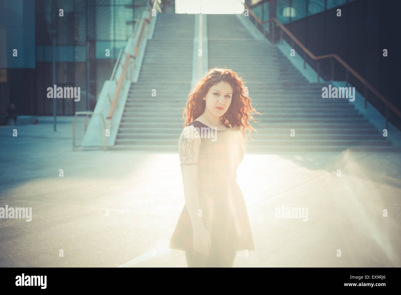 Belle jeune femme hippie avec les cheveux bouclés rouge dans la ville Banque D'Images