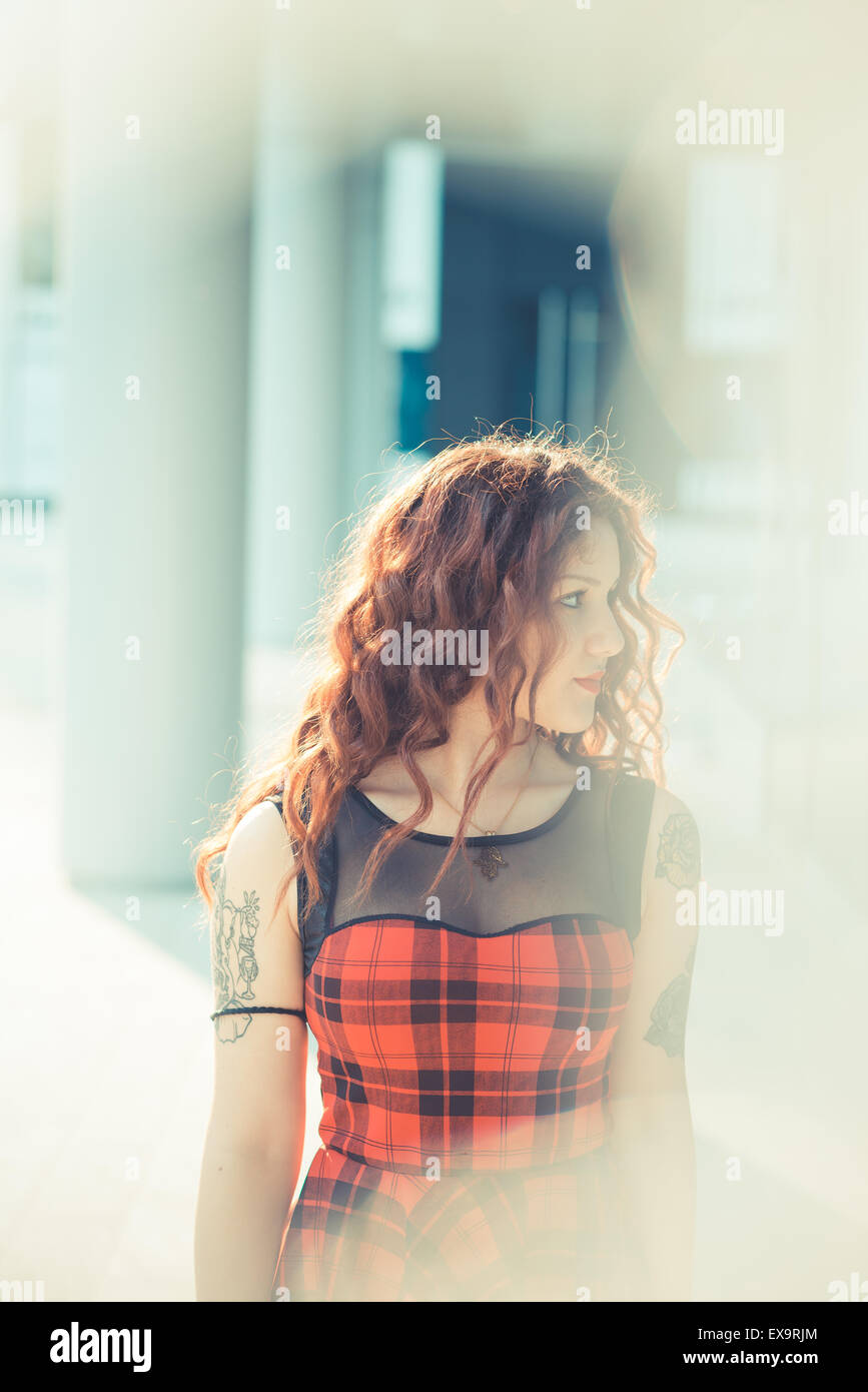 Belle jeune femme hippie avec les cheveux bouclés rouge dans la ville Banque D'Images
