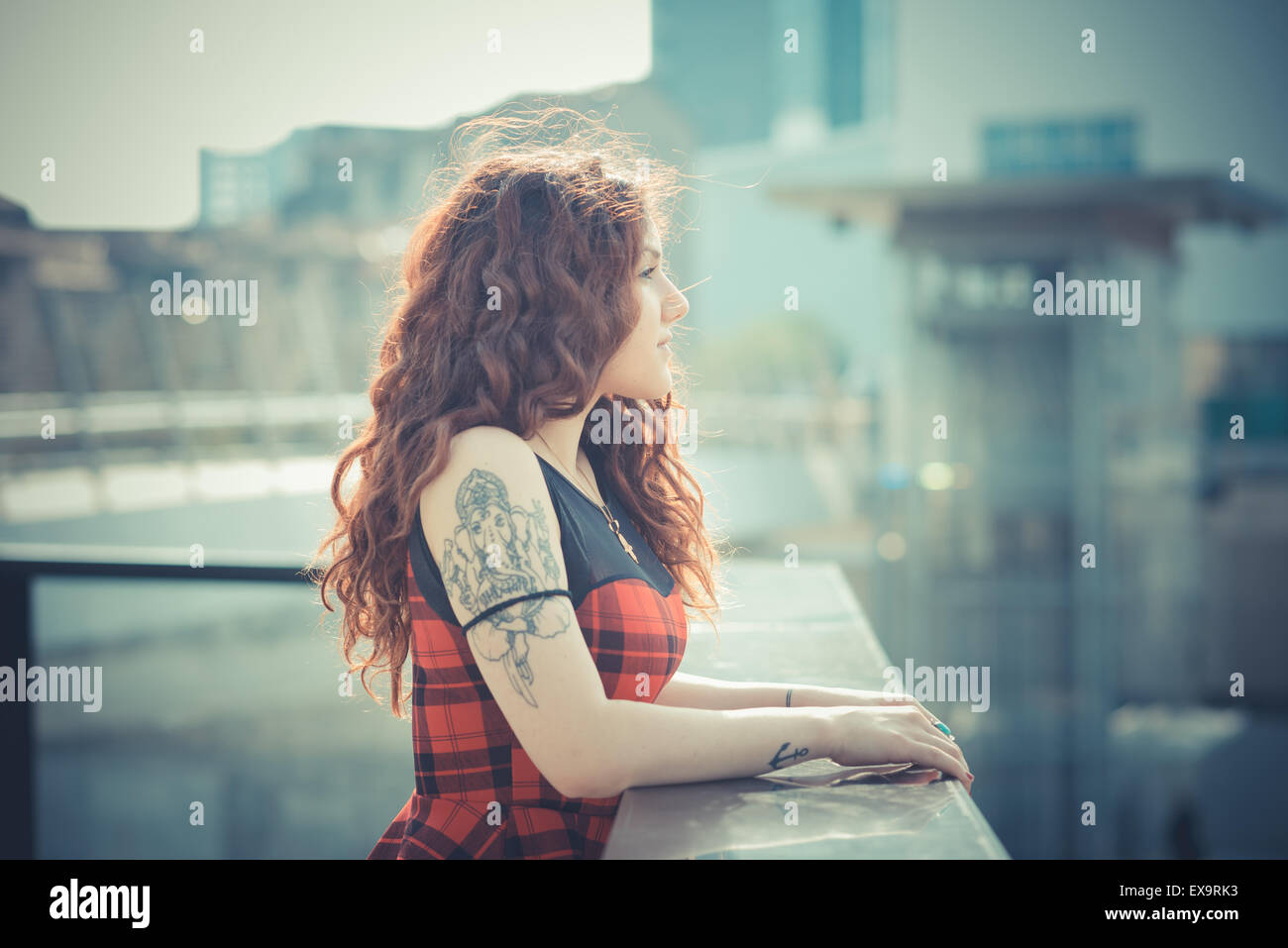 Belle jeune femme hippie avec les cheveux bouclés rouge dans la ville Banque D'Images