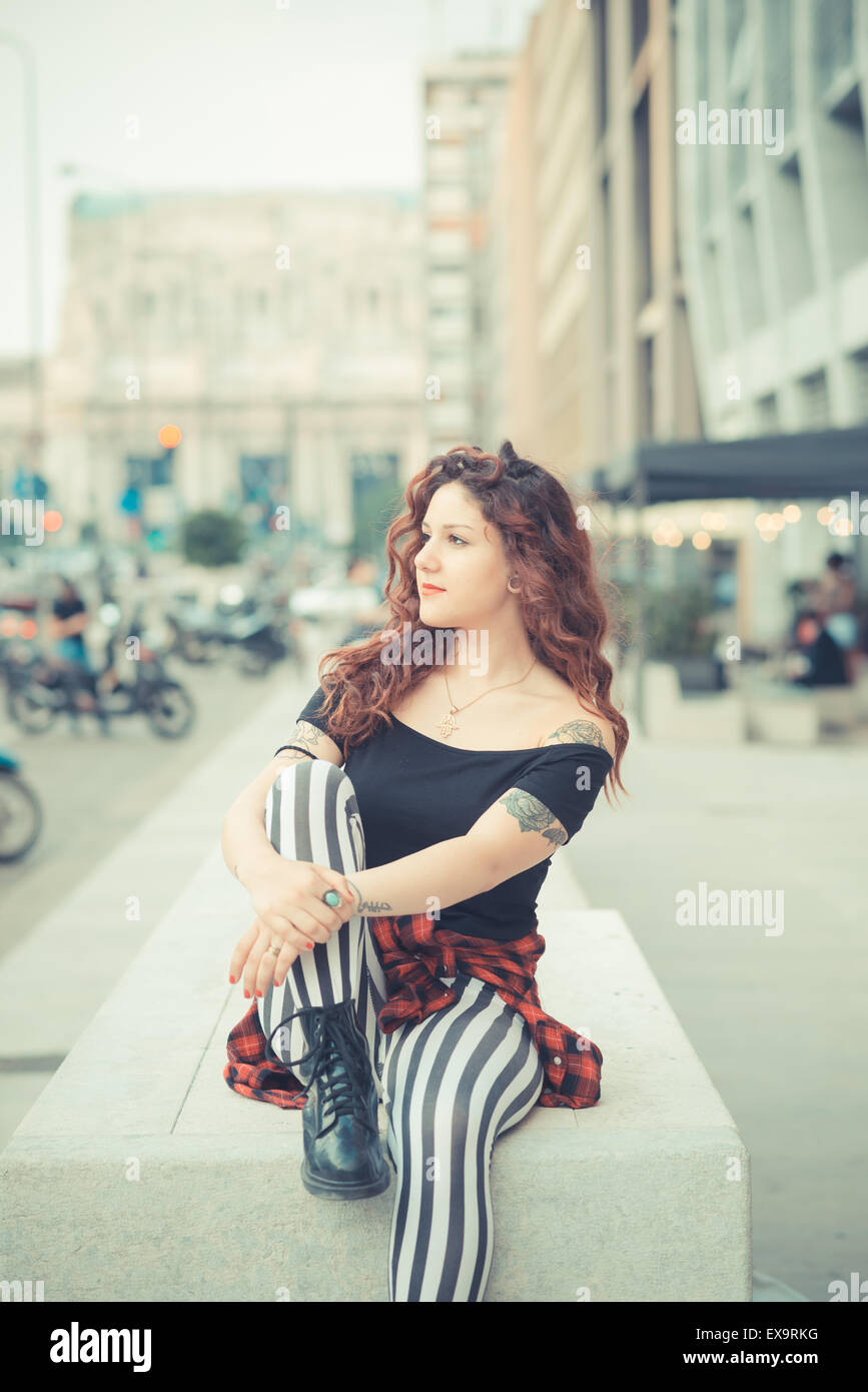 Belle jeune femme hippie avec les cheveux bouclés rouge dans la ville Banque D'Images