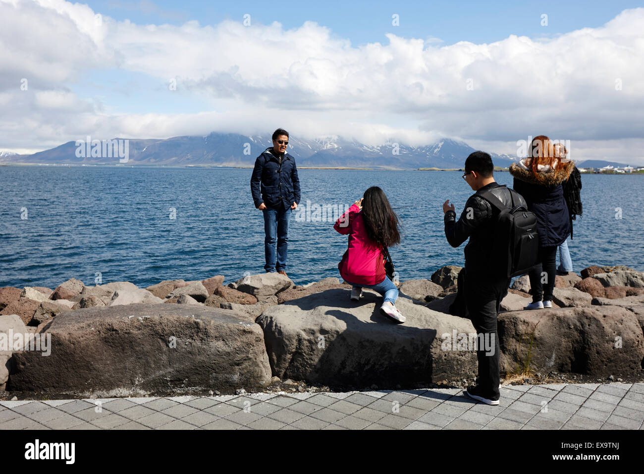 Les touristes asiatiques de prendre des photos sur la route côtière de la mer saebraut Reykjavik Islande Banque D'Images