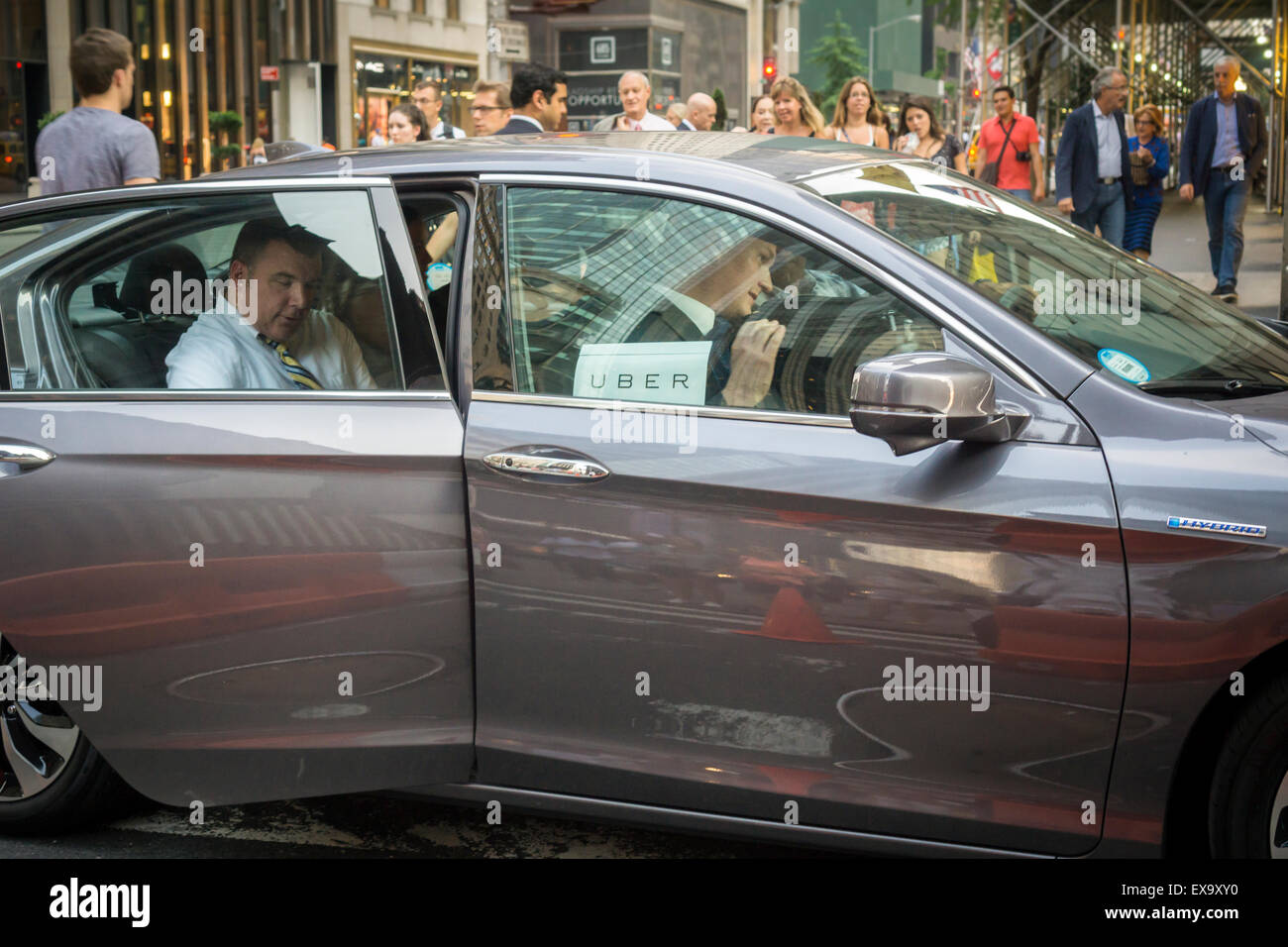 Riders grimpent dans une livrée Uber dans Midtown Manhattan à New York le Mardi, Juillet 7, 2015. Selon une enquête menée par le Comité pour la sécurité Taxi plus de la moitié des répondants préfèrent les taxis sur Uber sur le prix. Beat Uber Les taxis sur la commodité, la facilité de paiement et le temps d'attente aussi. (© Richard B. Levine) Banque D'Images