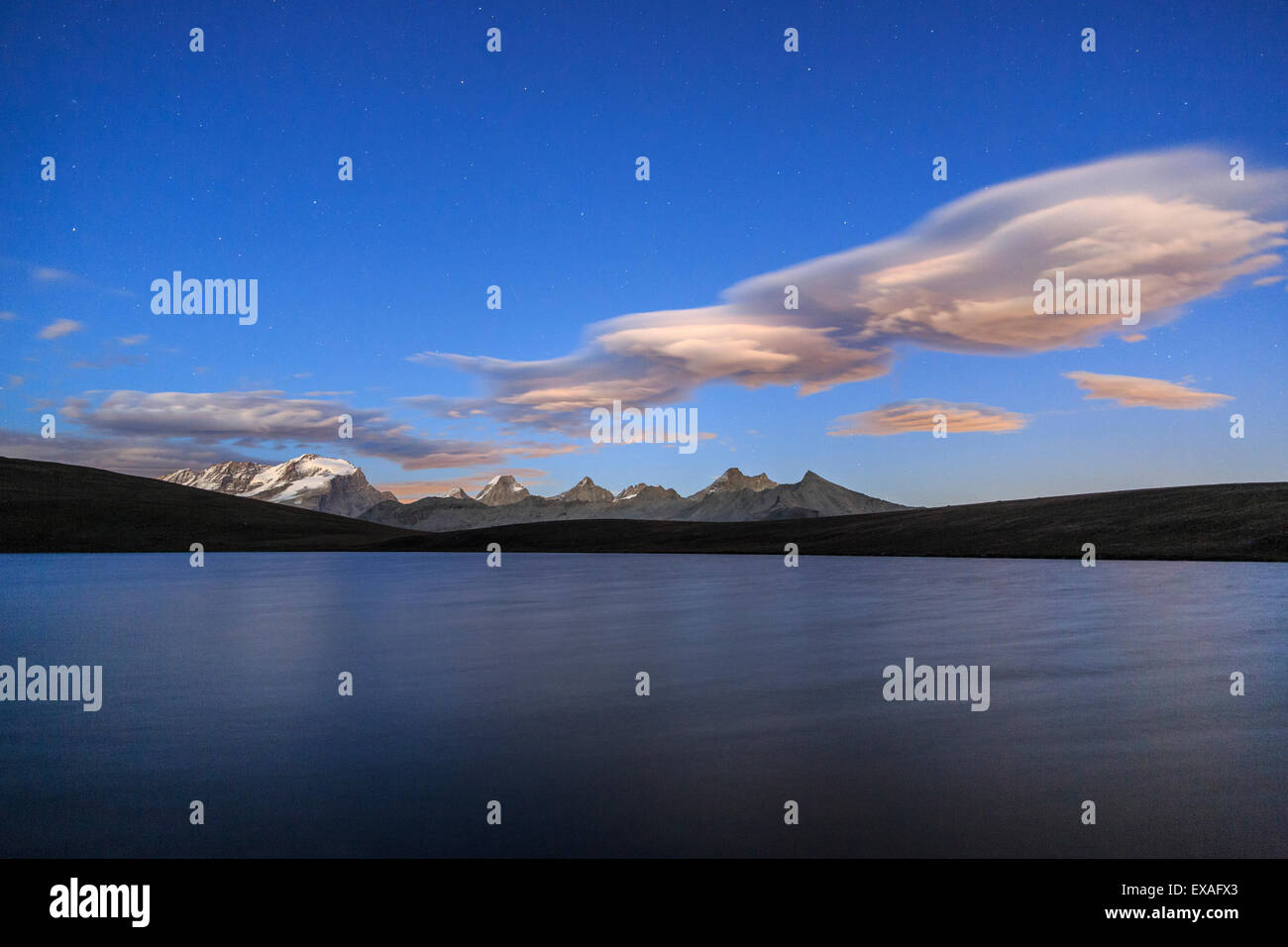 Nuages rose après le coucher du soleil sur le lac Rosset à une altitude de 2709 mètres, le Parc National du Gran Paradiso, Alpi Graie, Italie Banque D'Images