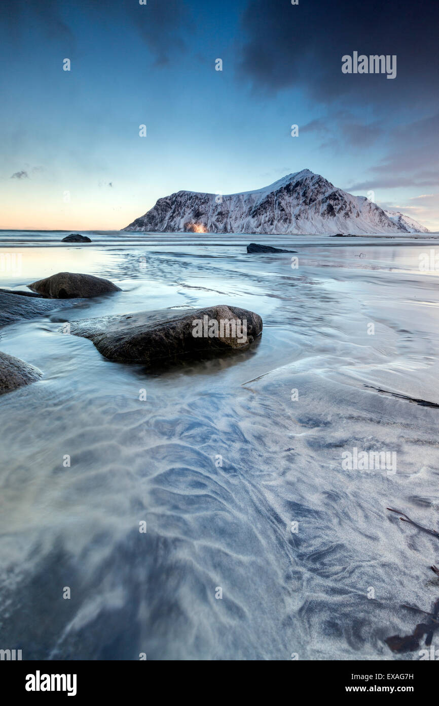 Coucher du soleil sur le surréel Skagsanden plage entourée de montagnes couvertes de neige, Flakstad, îles Lofoten, Norvège, de l'Arctique Banque D'Images