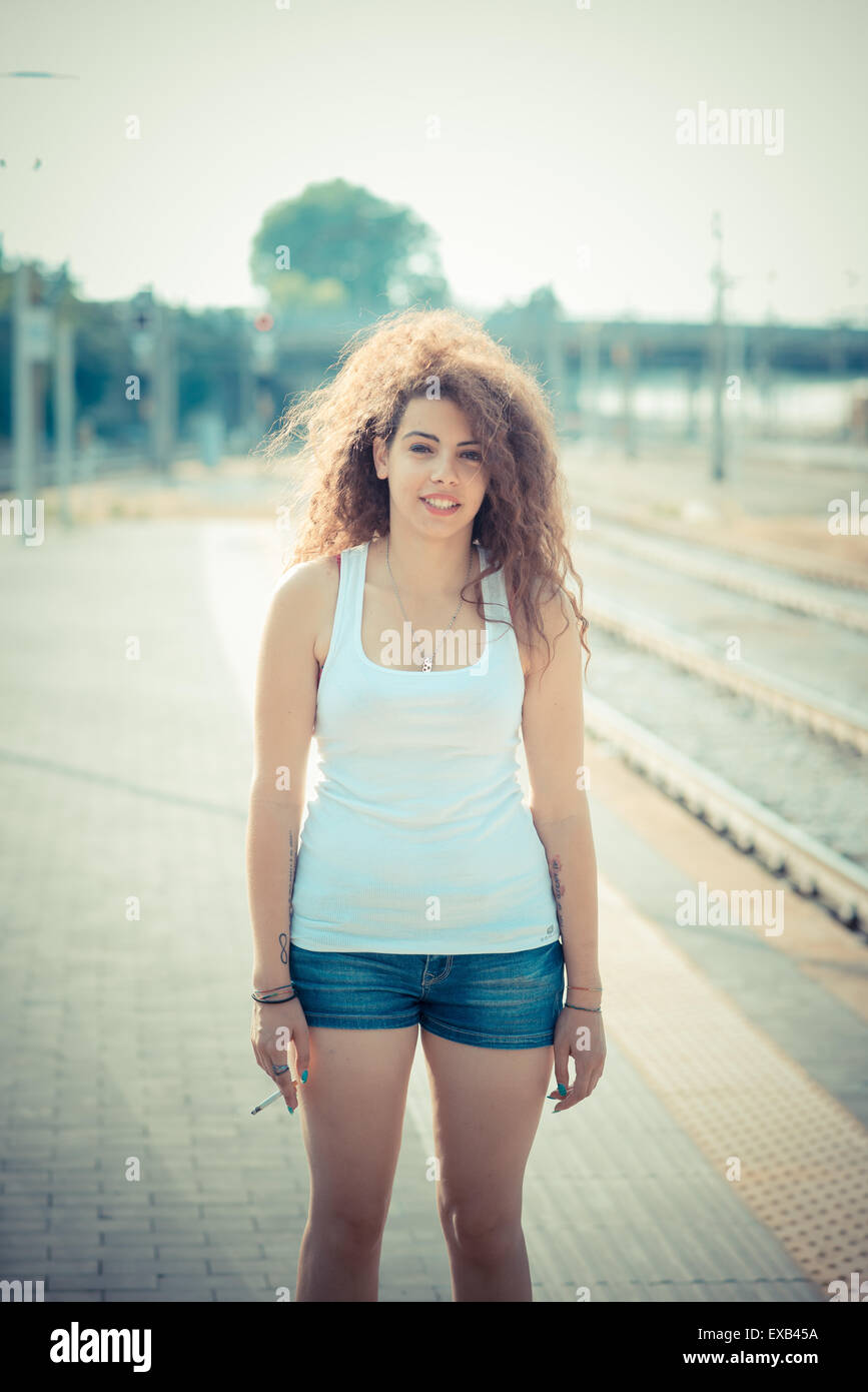 De beaux grands cheveux bouclés hipster femme dans la ville Banque D'Images
