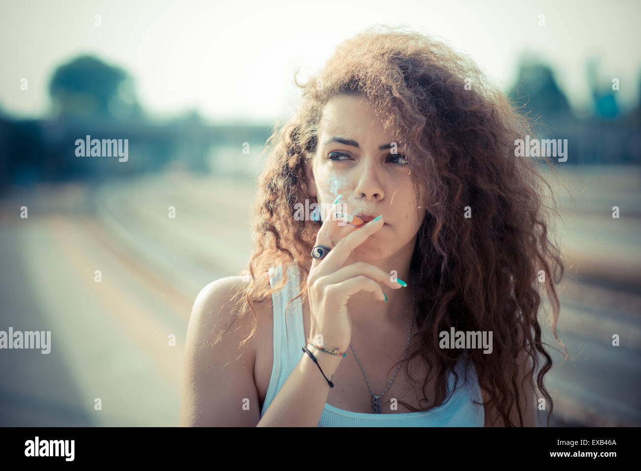 De beaux grands cheveux bouclés hipster femme dans la ville Banque D'Images