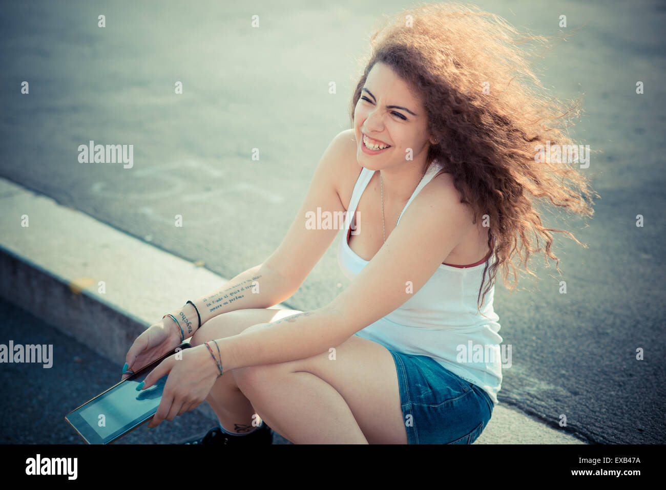 De beaux grands cheveux bouclés hipster femme dans la ville Banque D'Images