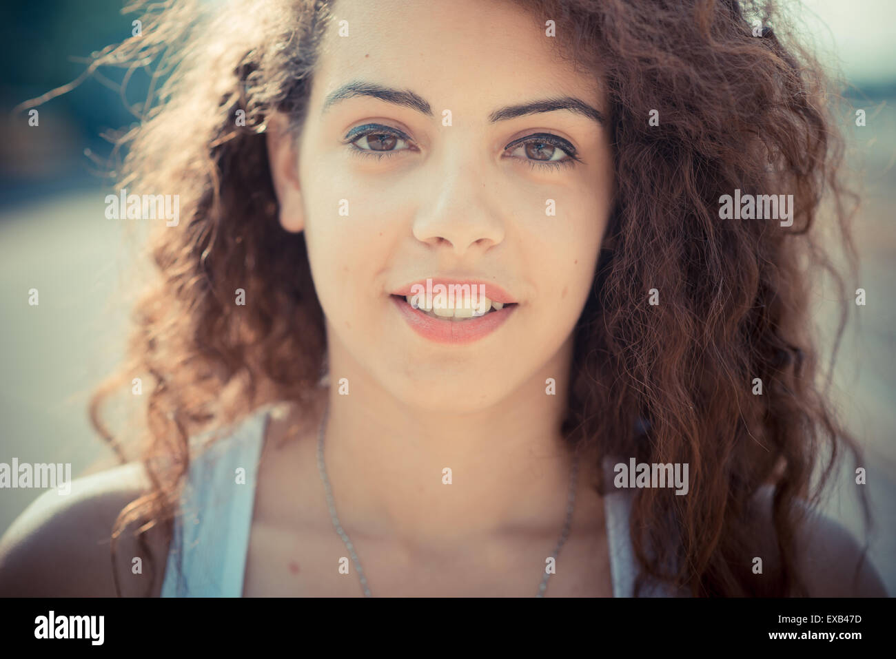 De beaux grands cheveux bouclés hipster femme dans la ville Banque D'Images