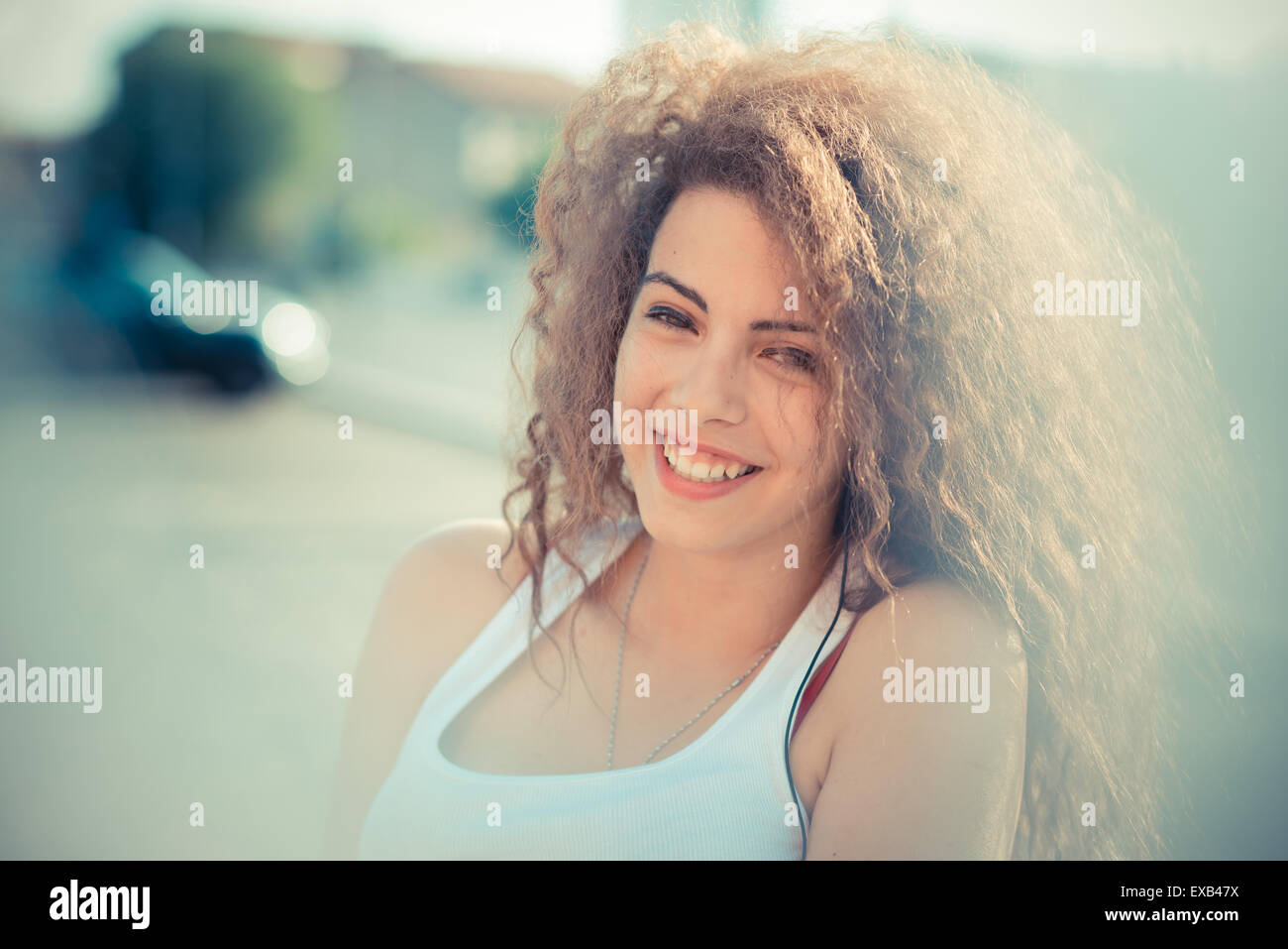 De beaux grands cheveux bouclés hipster femme dans la ville Banque D'Images