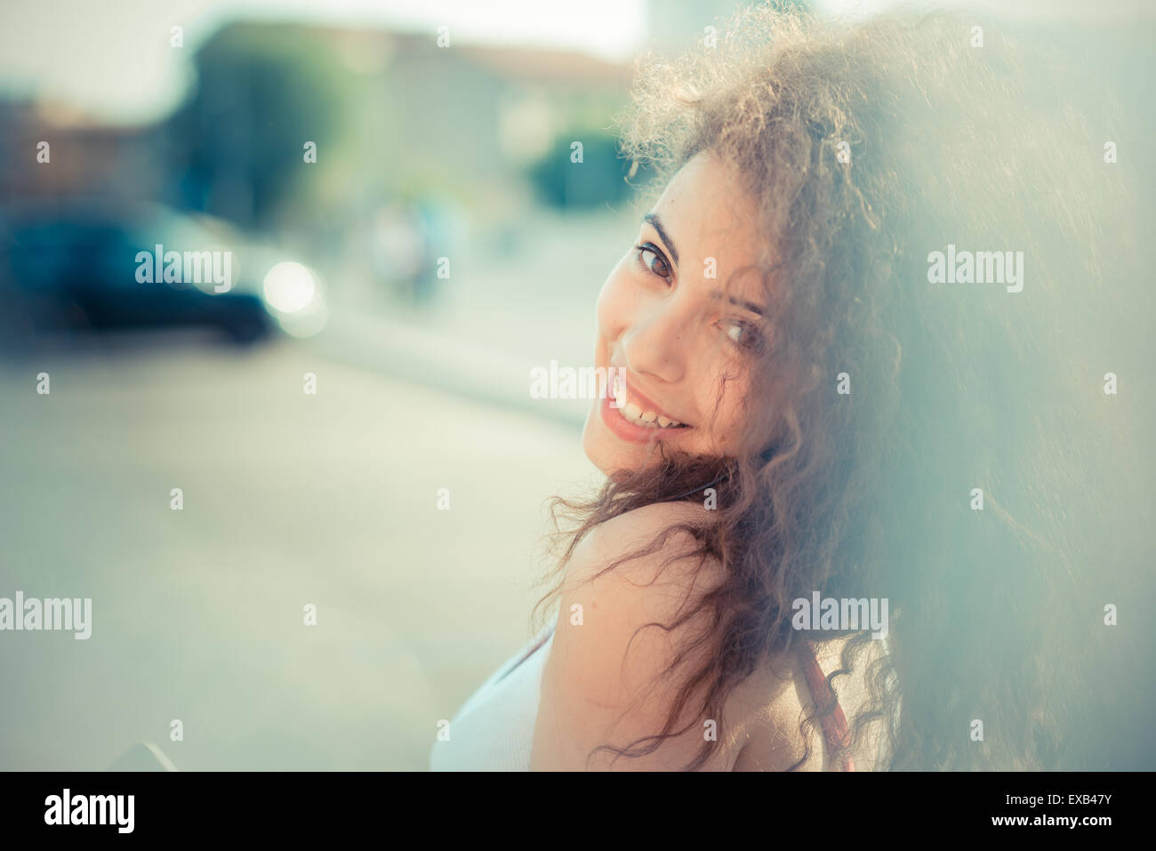 De beaux grands cheveux bouclés hipster femme dans la ville Banque D'Images