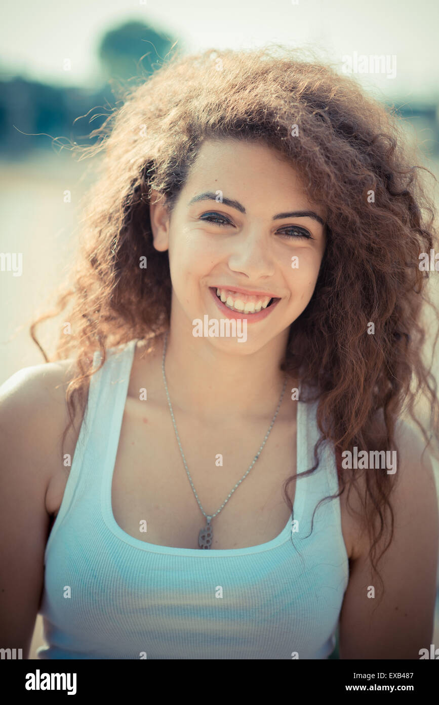 De beaux grands cheveux bouclés hipster femme dans la ville Banque D'Images