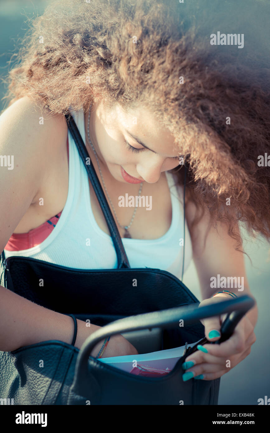 De beaux grands cheveux bouclés hipster femme dans la ville Banque D'Images