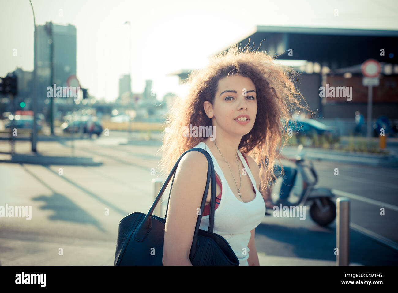 De beaux grands cheveux bouclés hipster femme dans la ville Banque D'Images