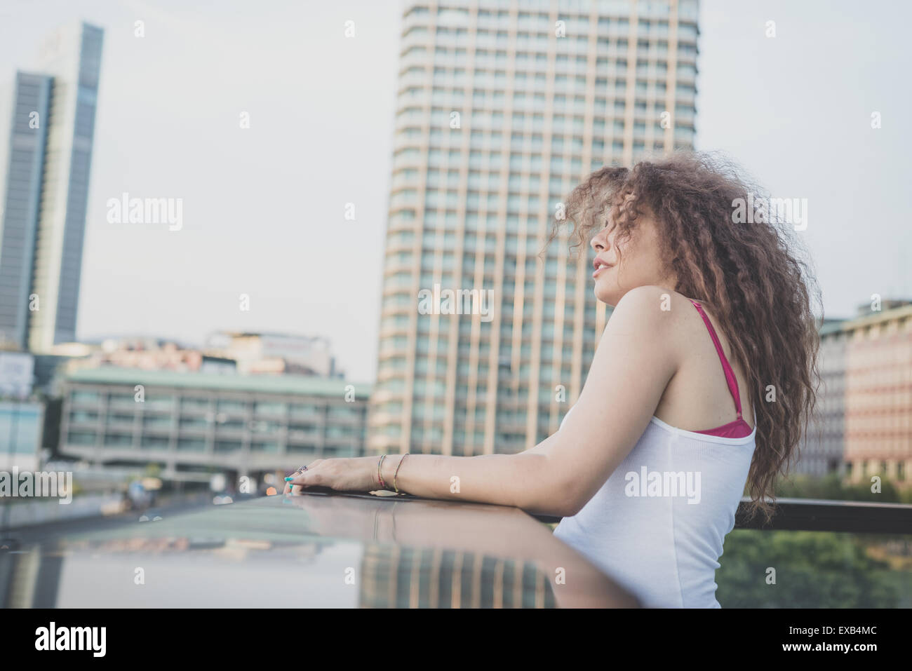 De beaux grands cheveux bouclés hipster femme dans la ville Banque D'Images