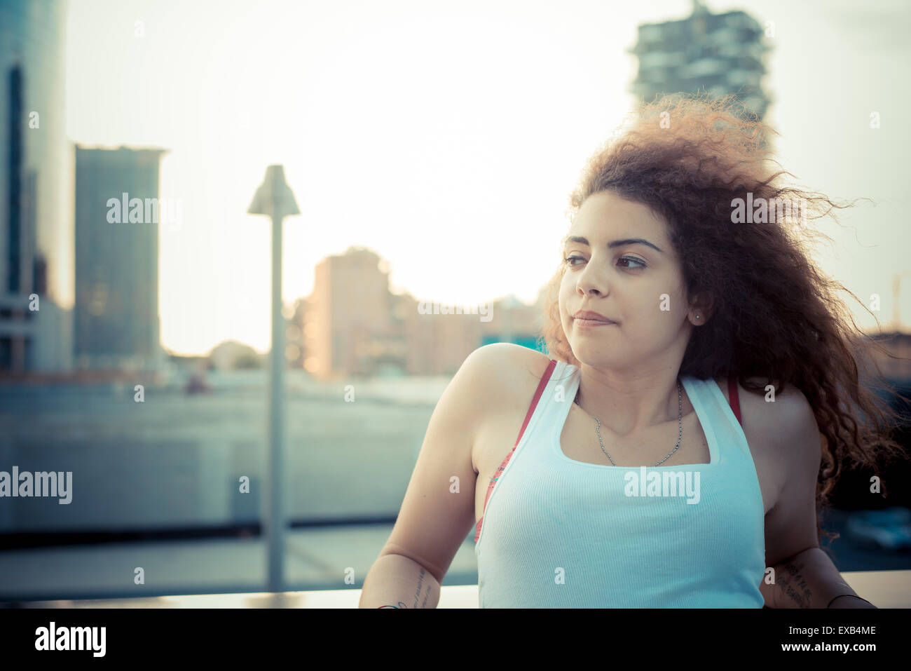 De beaux grands cheveux bouclés hipster femme dans la ville Banque D'Images
