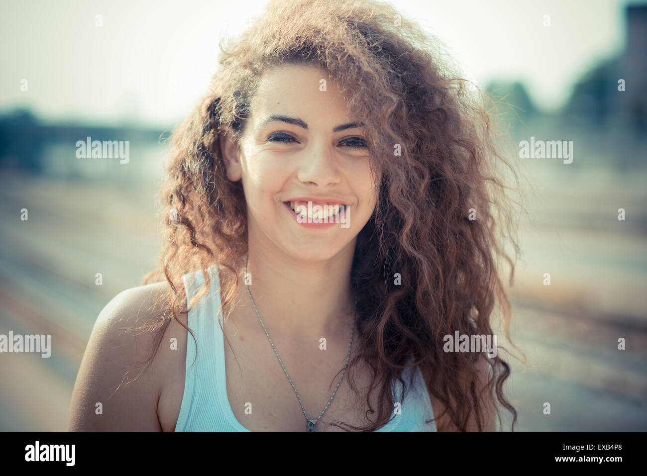 De beaux grands cheveux bouclés hipster femme dans la ville Banque D'Images