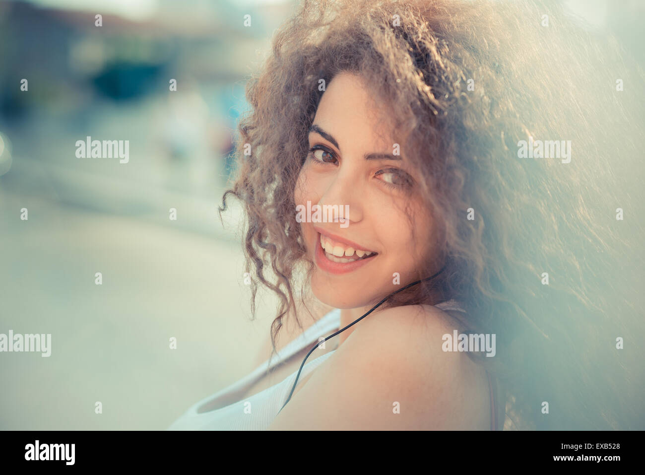 De beaux grands cheveux bouclés hipster femme dans la ville Banque D'Images