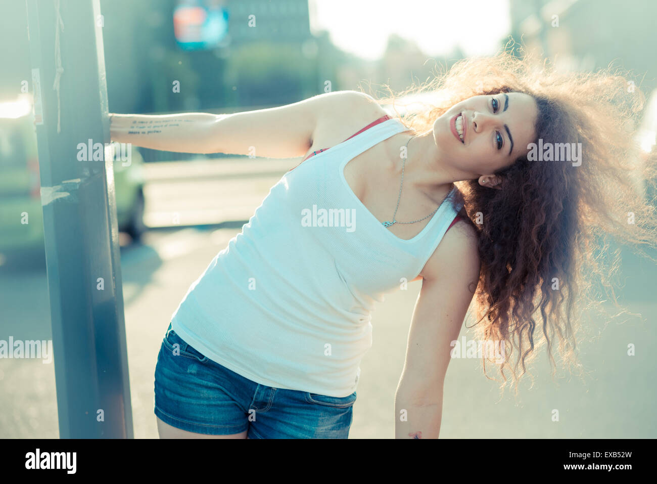 De beaux grands cheveux bouclés hipster femme dans la ville Banque D'Images