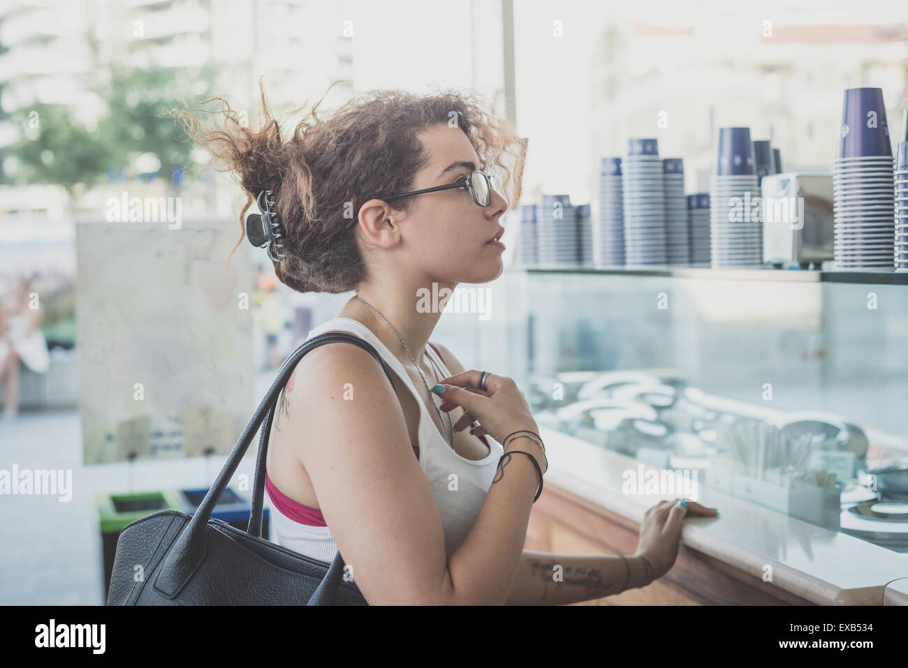 De beaux grands cheveux bouclés hipster femme dans la ville Banque D'Images