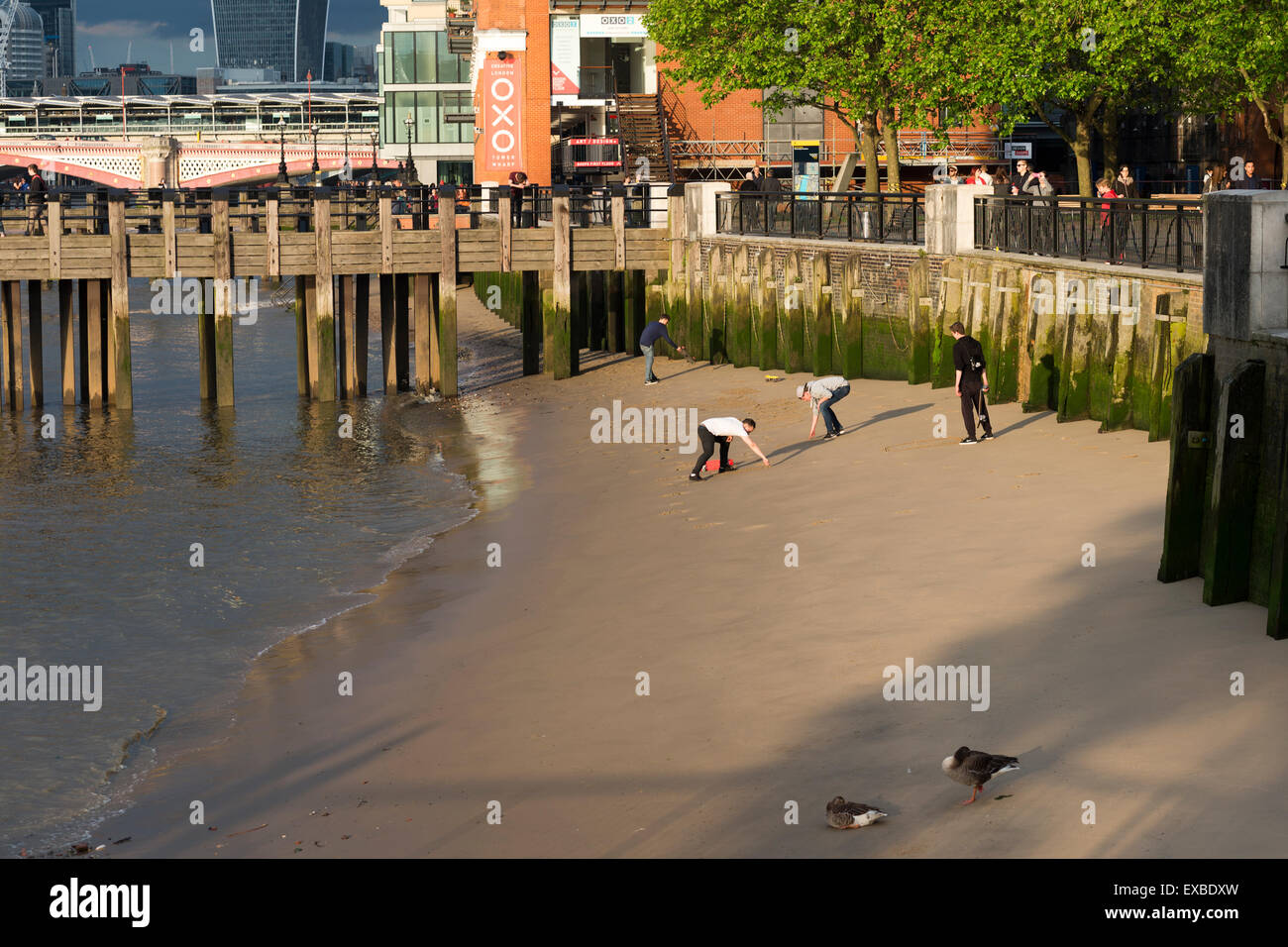Personnes jouant sur une plage près de la rivière Thames & Oxo Tower Gabriel's Wharf, Southbank London, England, UK. Banque D'Images
