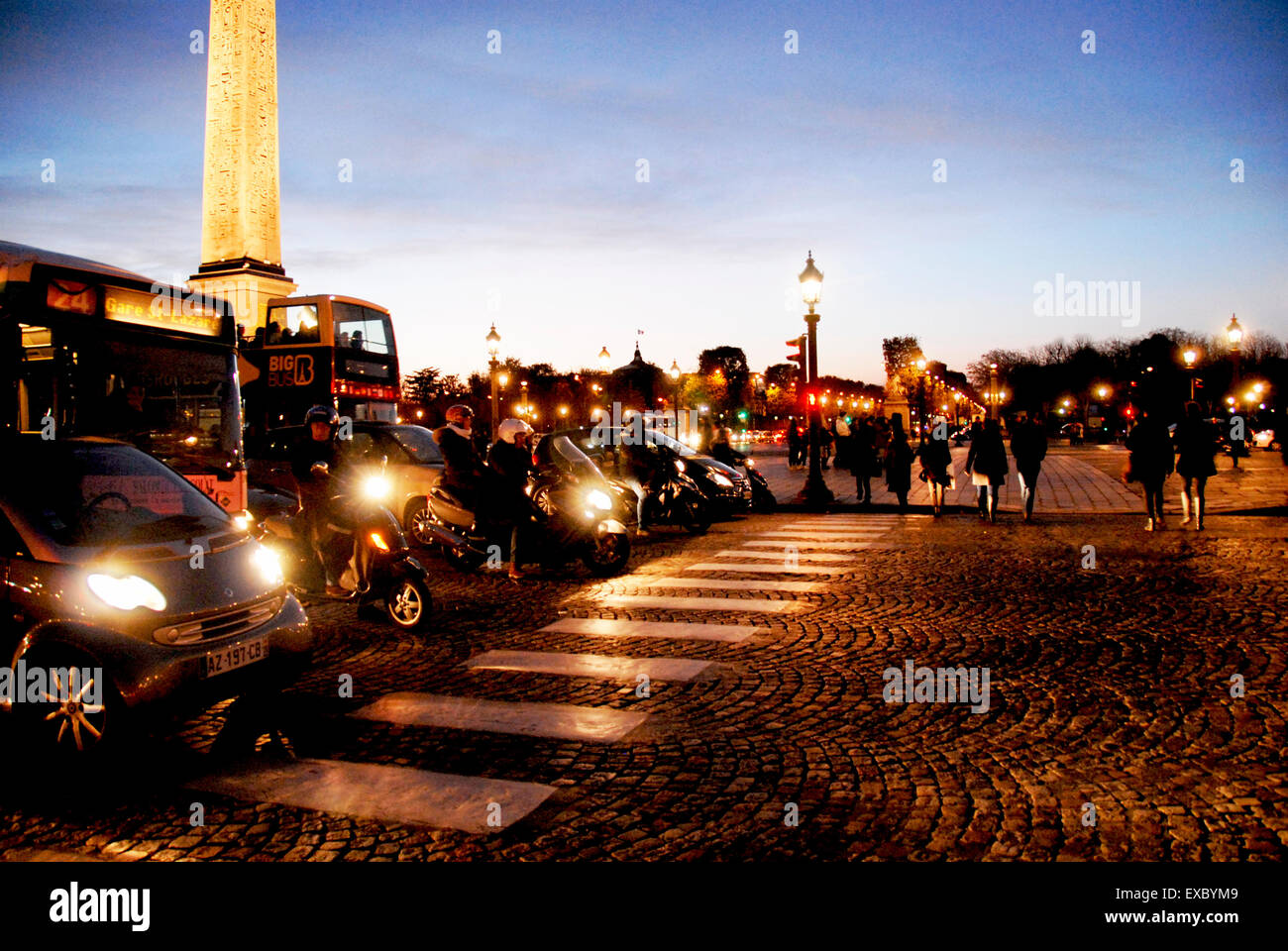 Les piétons traversant la Place de la Concorde, Paris, France, au coucher du soleil, Feux de circulation sur Red Banque D'Images