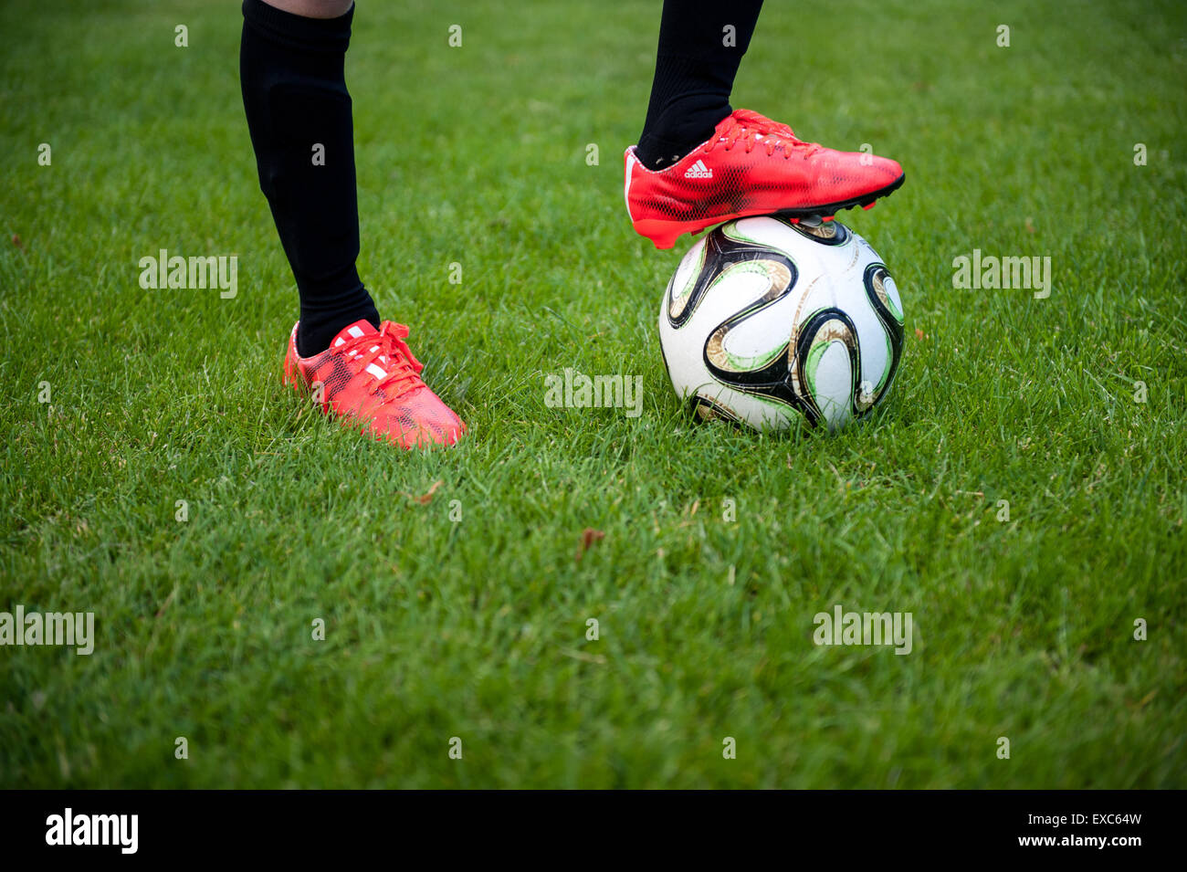 Portrait d'un jeune garçon avec son pied sur un terrain de football Banque D'Images