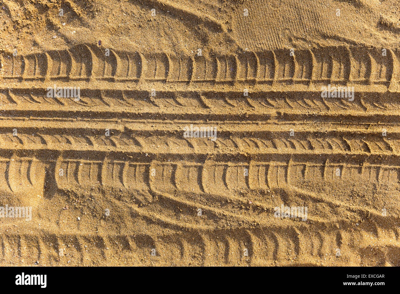 Des traces de bande de roulement de roue sur une plage de sable Banque D'Images