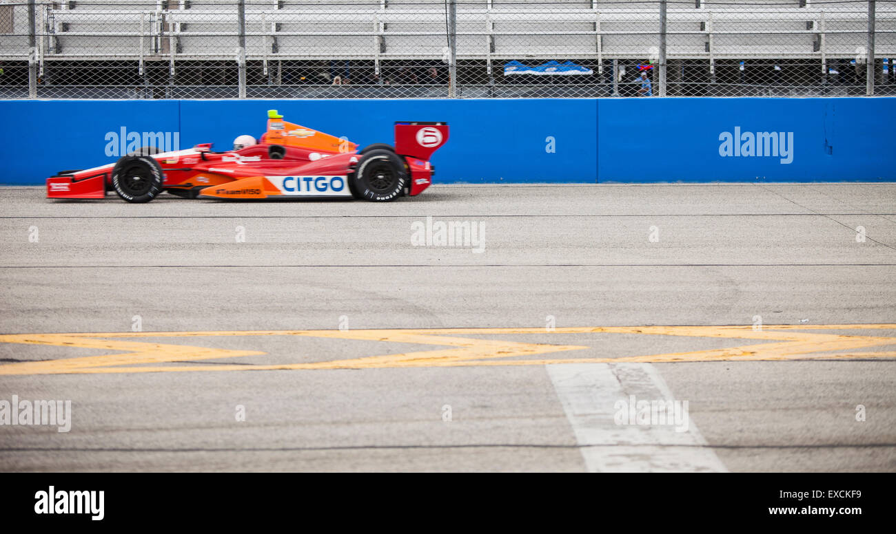 Une voiture de course rouge d'indyCar à cheval sur un hippodrome. Banque D'Images