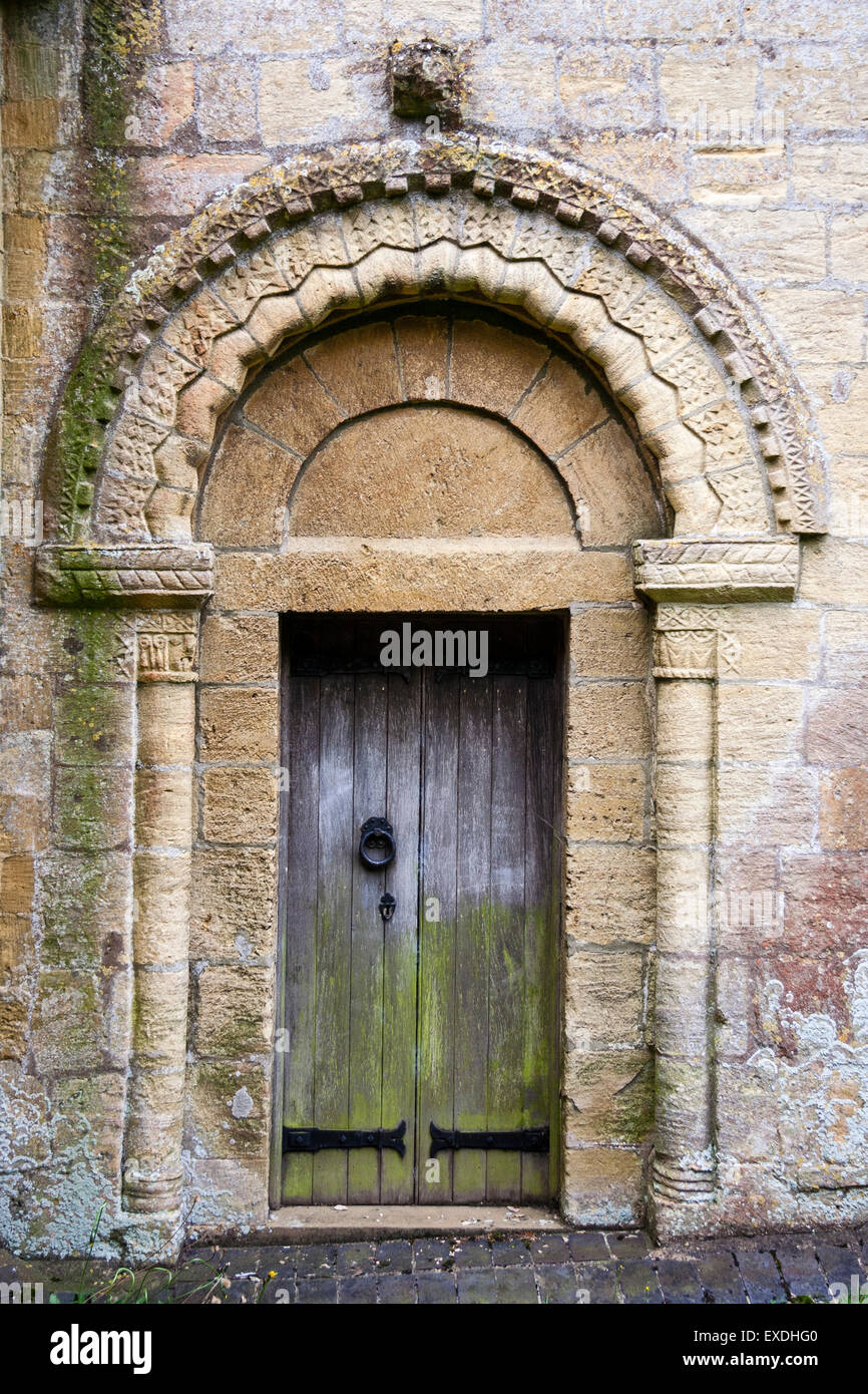 Village anglais de Guiting Power. L'église de St Michael avec l'un de l'autre période Normande porte montrant la sculpture du tympan. Banque D'Images