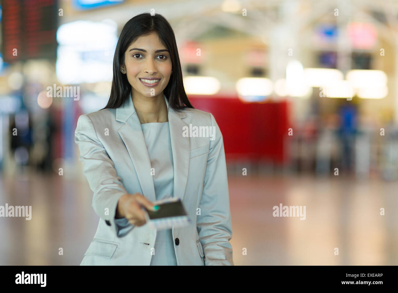 Happy Indian woman handing over air ticket au comptoir de compagnie aérienne Banque D'Images