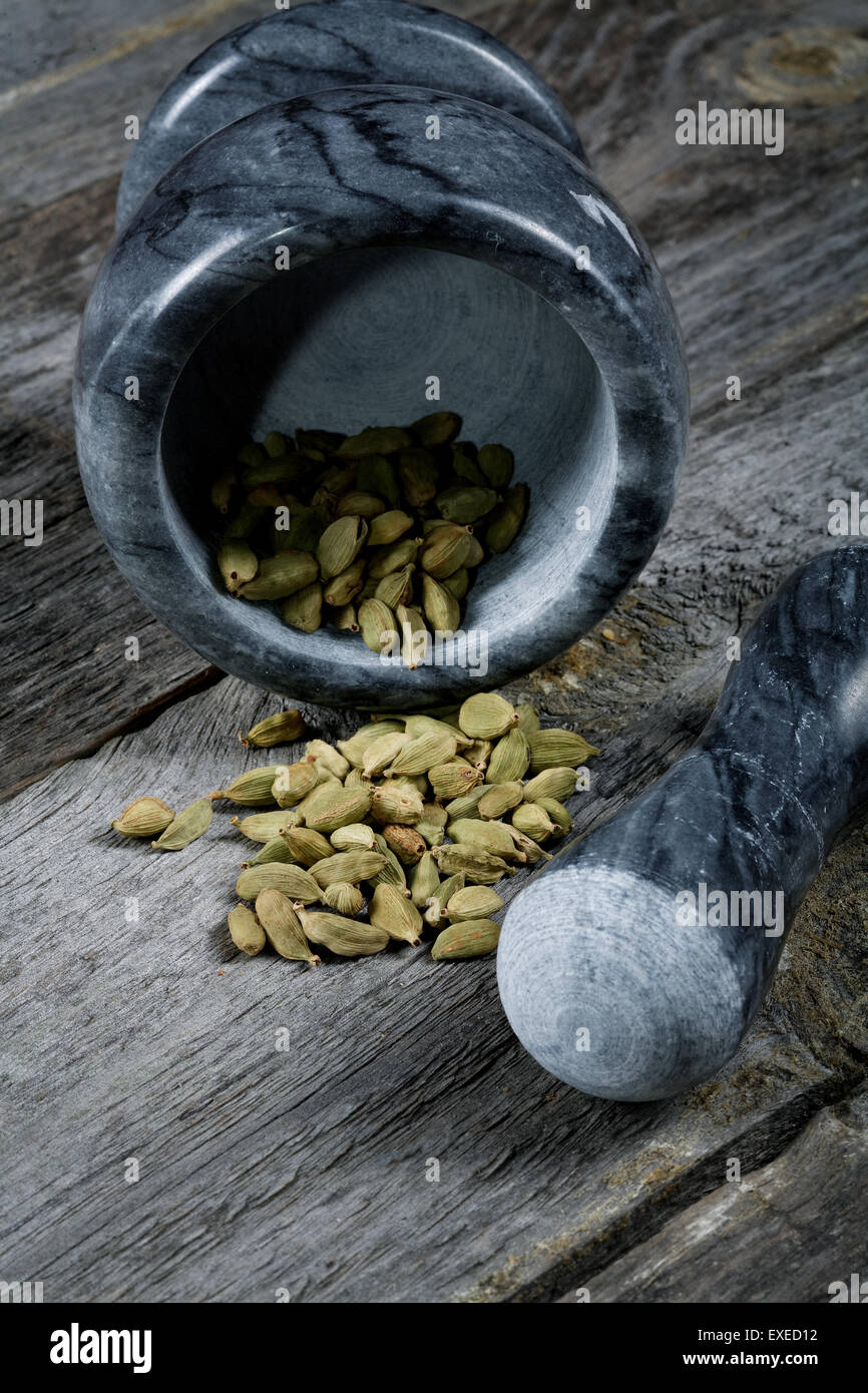 De cardamome au mortier sur une vieille table de cuisine Banque D'Images