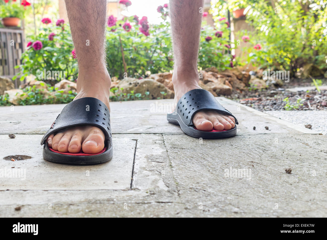Les pieds nus de garçon en noir chaussons avec jambes poilues dans votre  arrière-cour Photo Stock - Alamy
