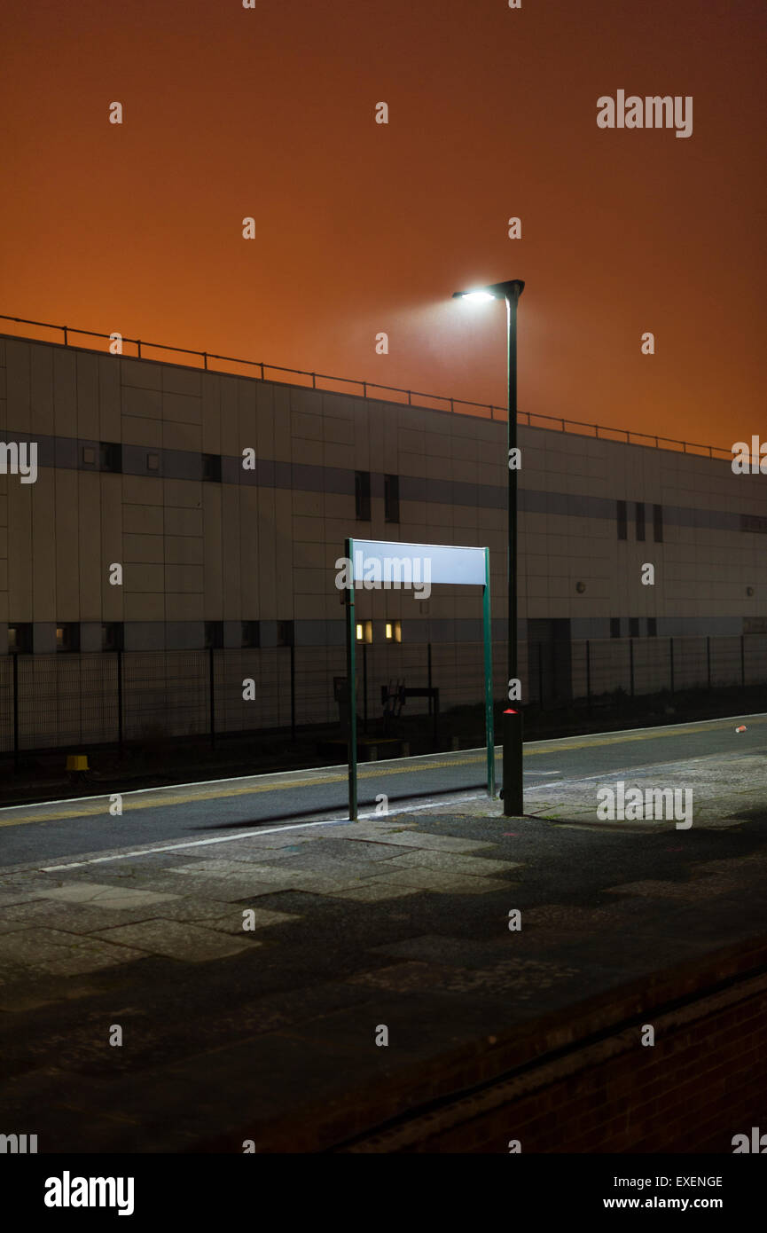 Une gare déserte vide avec un signe d'emplacement vide dans la nuit dans le Brouillard Le brouillard UK Banque D'Images