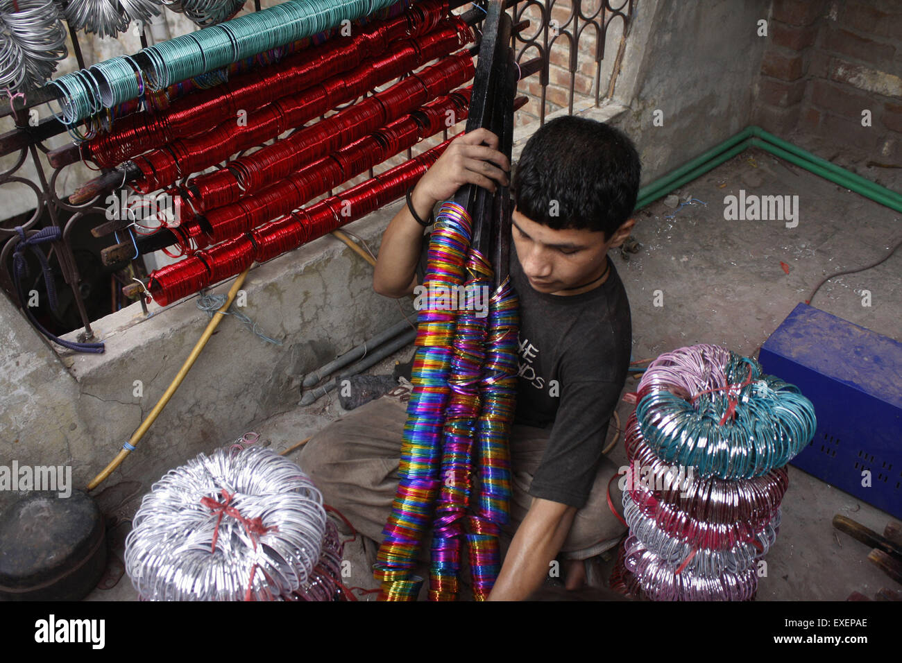 Lahore. Le 13 juillet, 2015. Un salarié travaille dans une usine avant de bangle de l'Eid al-Fitr festival à l'est du Pakistan, Lahore, 13 juillet 2015. La demande de bangle augmente avant l'aïd vacances au Pakistan. © Jamil Ahmed/Xinhua/Alamy Live News Banque D'Images