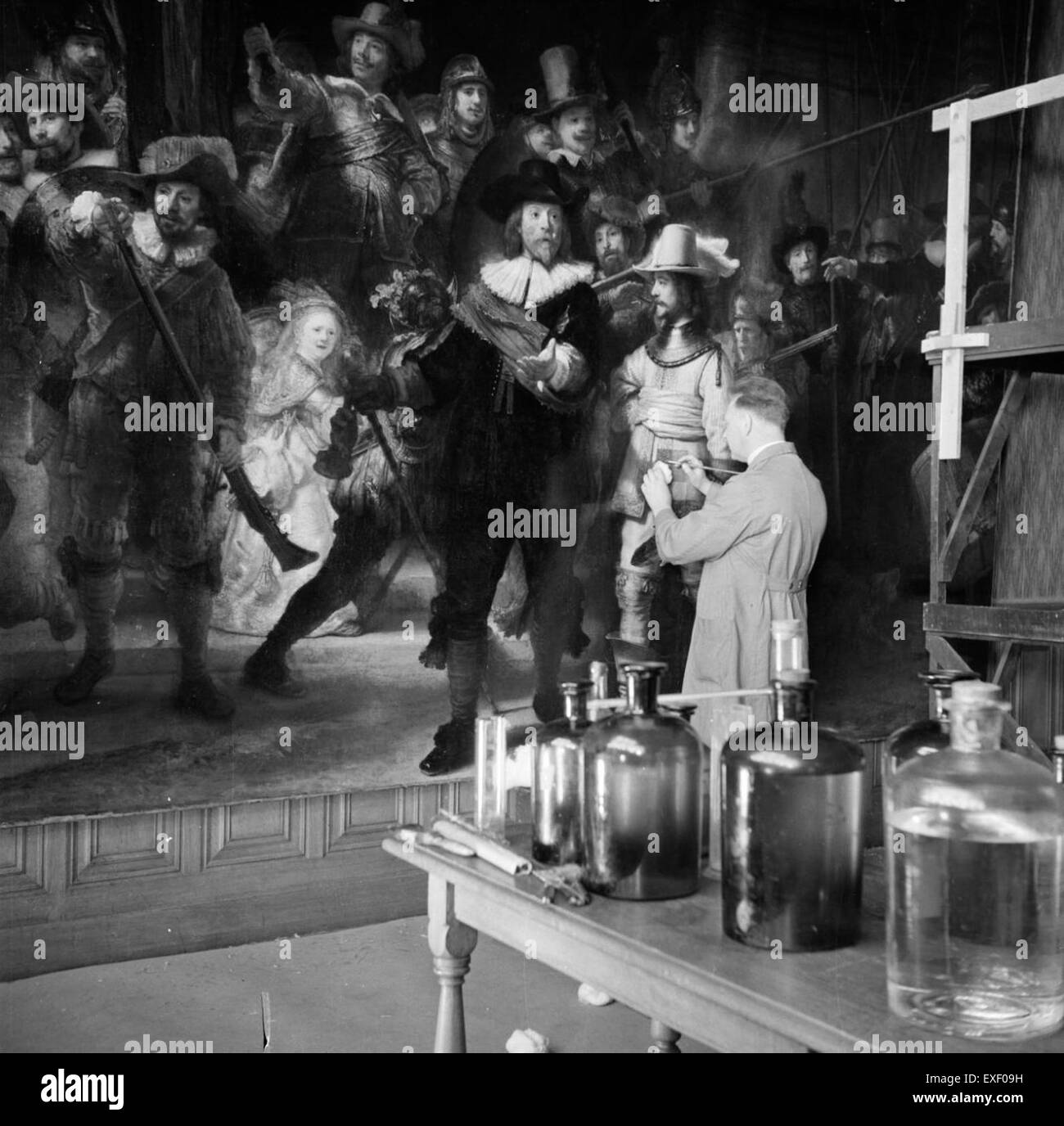 Un expert en restauration travaille sur le célèbre tableau « The Night Watch » au Rijksmuseum d'Amsterdam. Le processus implique un soin méticuleux pour préserver ce chef-d’œuvre historique. Banque D'Images