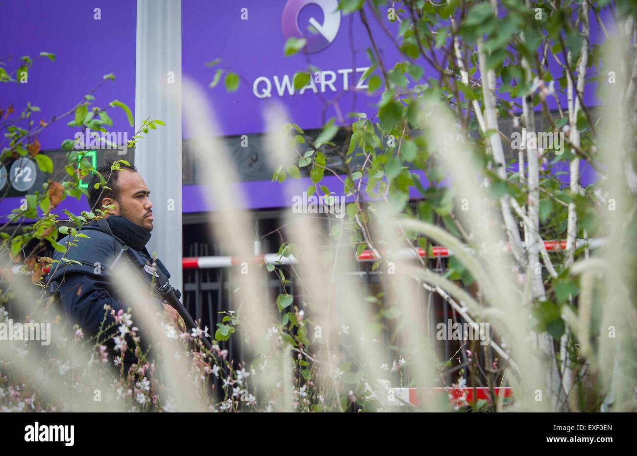 Paris, France. Le 13 juillet, 2015. Un policier monte la garde à l'extérieur de l'emplacement d'un otage helding à Paris, France, le 13 juillet 2015. Environ 18 personnes ont été évacuées du centre commercial où les employés en otage des hommes armés qui s'est tenue lundi matin à Villeneuve-la-Garenne, ouest de Paris, a annoncé la police. Crédit : Chen Xiaowei/Xinhua/Alamy Live News Banque D'Images Paris, France. Le 13 juillet, 2015. Un policier monte la garde à l'extérieur de l'emplacement d'un otage helding à Paris, France, le 13 juillet 2015. Environ 18 personnes ont été évacuées du centre commercial où les employés en otage des hommes armés qui s'est tenue lundi matin à Villeneuve-la-Garenne, ouest de Paris, a annoncé la police. Crédit : Chen Xiaowei/Xinhua/Alamy Live News Banque D'Images