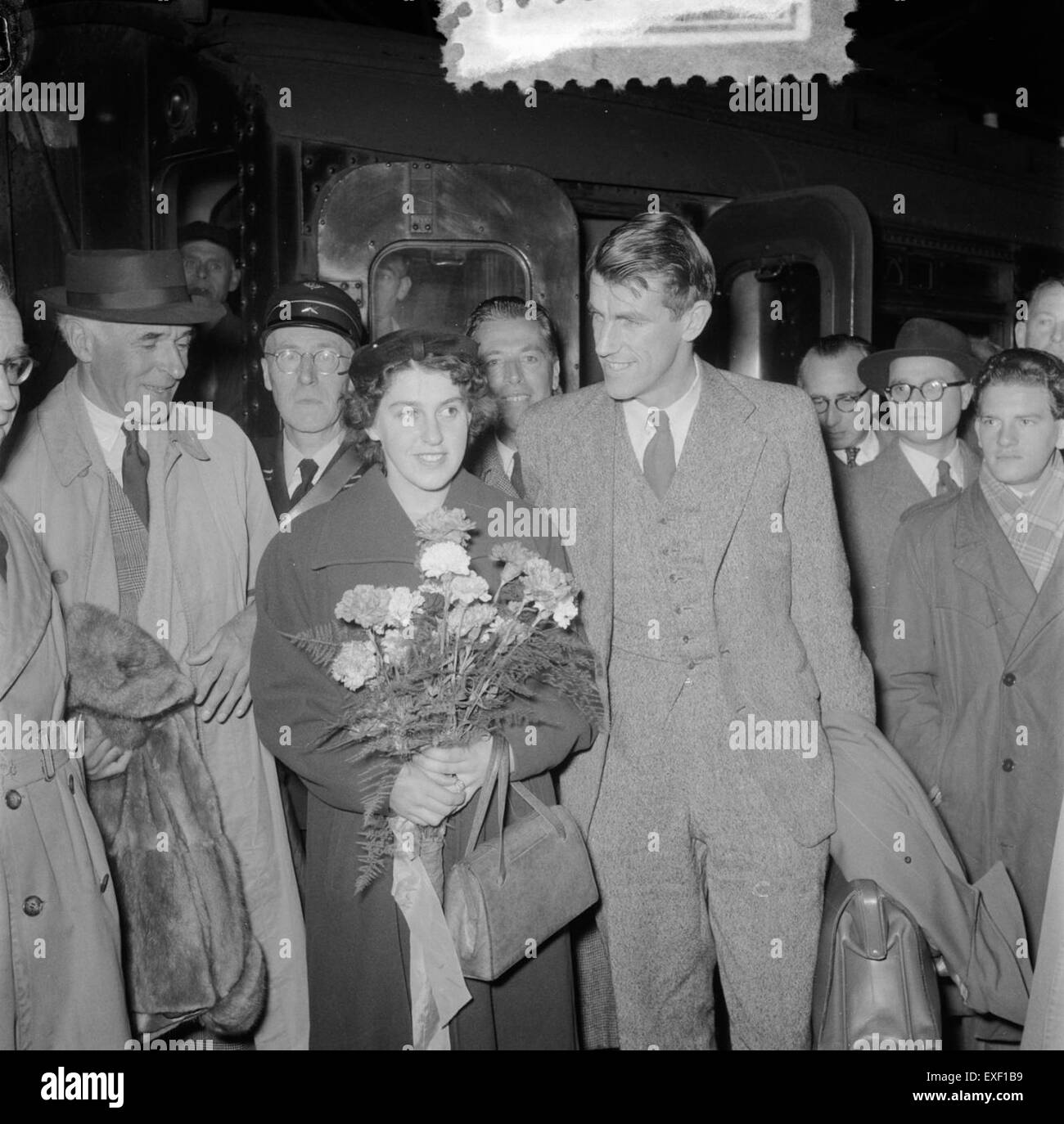 Cette photographie historique capture l'arrivée de Sir Edmund Hillary à Amsterdam, après son ascension emblématique de l'Everest en 1953. L'image reflète la célébration mondiale de son accomplissement et sa réception par le public. Banque D'Images