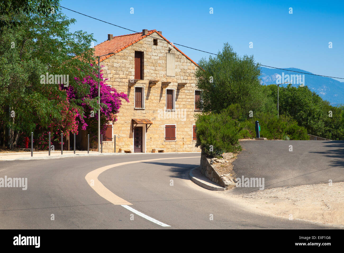 Figari, Corse du Sud. Vieille maison rurar en pierre avec toit en tuiles rouges près de la route d'asphalte Banque D'Images