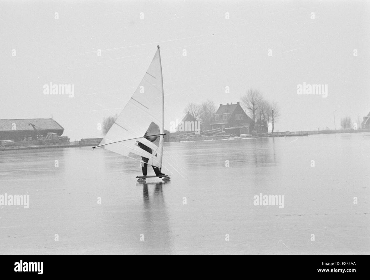 L'IJszeilen, ou voile sur glace, est un sport d'hiver populaire aux pays-Bas, où les participants courent sur glace en utilisant des voiles attachées à des patins ou des traîneaux. L'image capture la nature palpitante et unique de ce sport, combinant vitesse, glace et vent. Banque D'Images