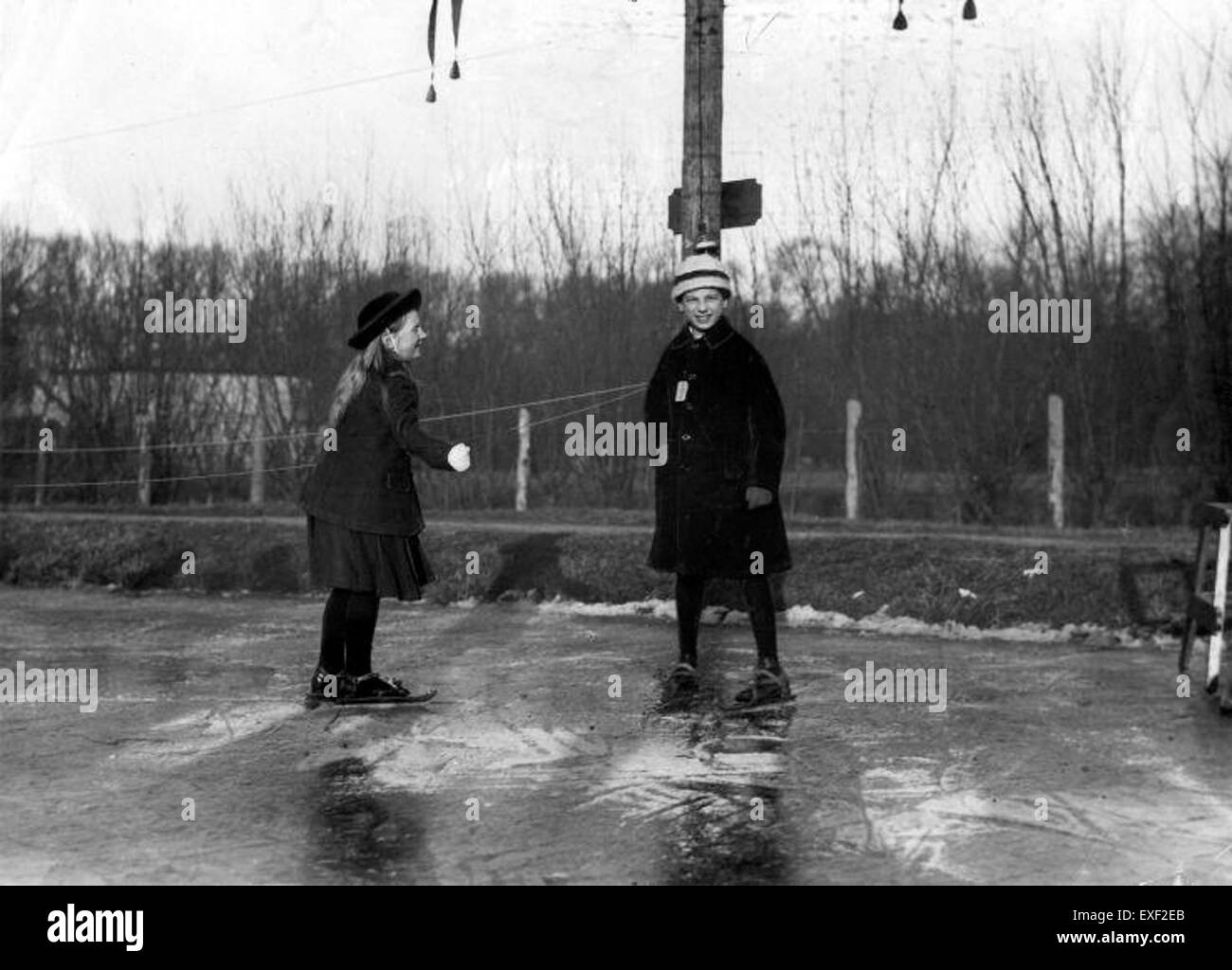 Cette image montre Juliana patinant avec un compagnon, illustrant une activité de loisirs du début du XXe siècle. Le moment souligne la popularité des sports d'hiver et des interactions sociales au cours de l'époque. Banque D'Images