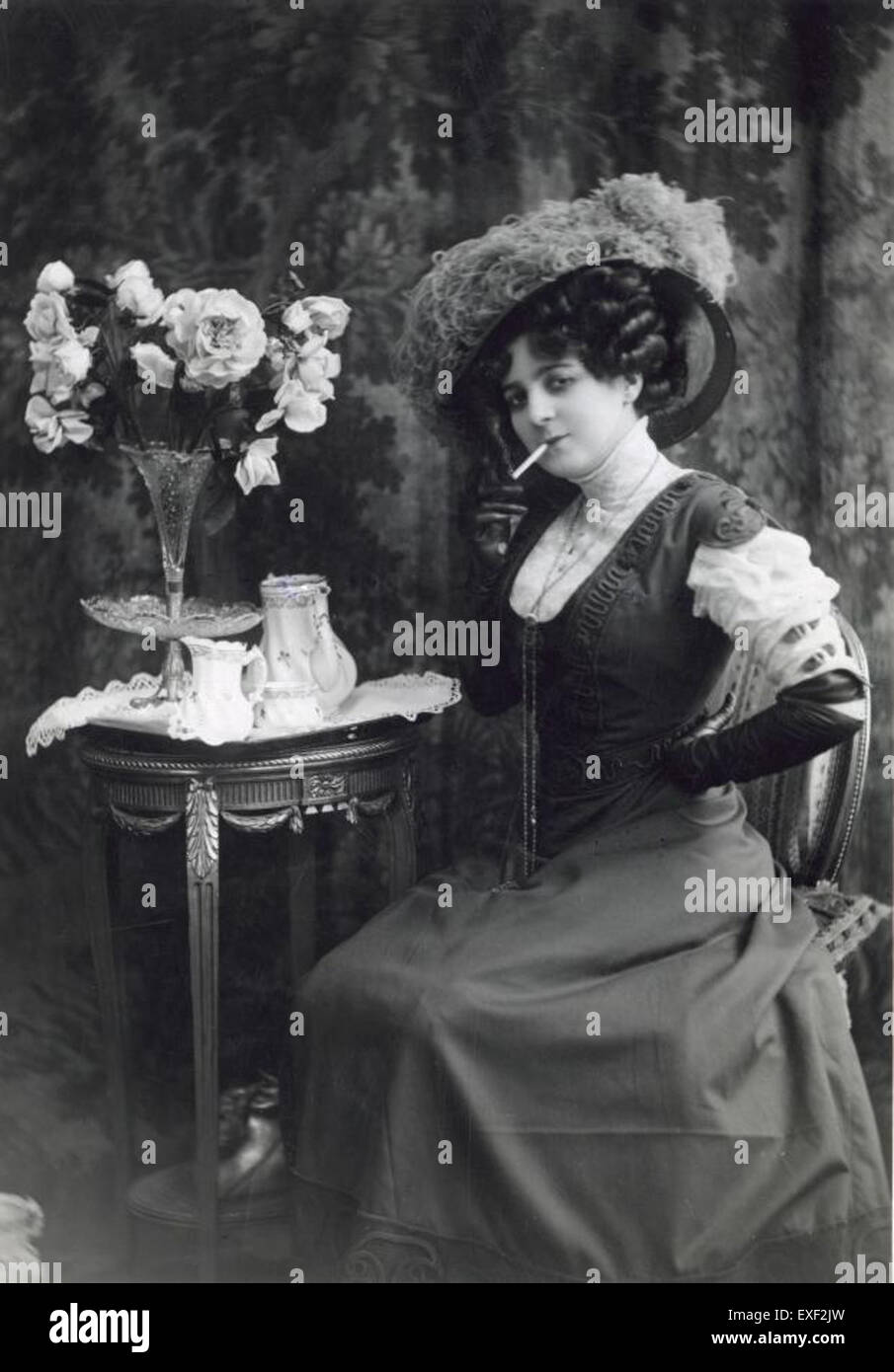 Ce croquis de mode français du XIXe siècle représente une femme dans une robe à encolure basse en dentelle, associée à un chapeau en plumes d'autruche à plumes. La représentation détaillée illustre l'élégance et les tendances de l'époque, avec une attention particulière aux textures de la dentelle et de la plume. Banque D'Images