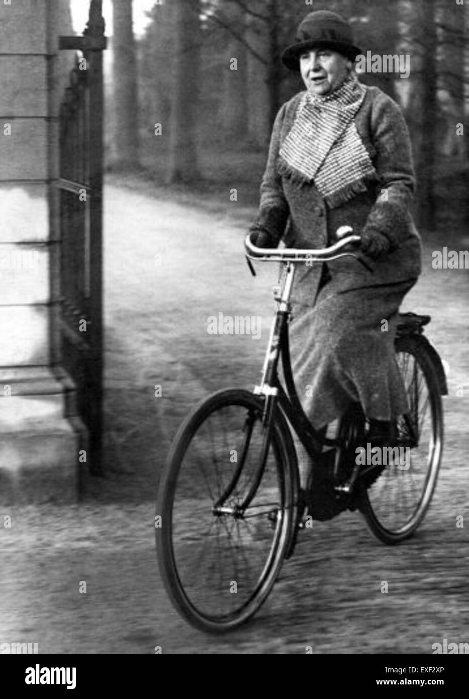 Cette photographie capture la reine Wilhelmine des pays-Bas à vélo, offrant un aperçu rare de sa vie personnelle et un moment de loisir royal. Il reflète son approche active et moderne de la vie publique durant son règne au début du XXe siècle. Banque D'Images