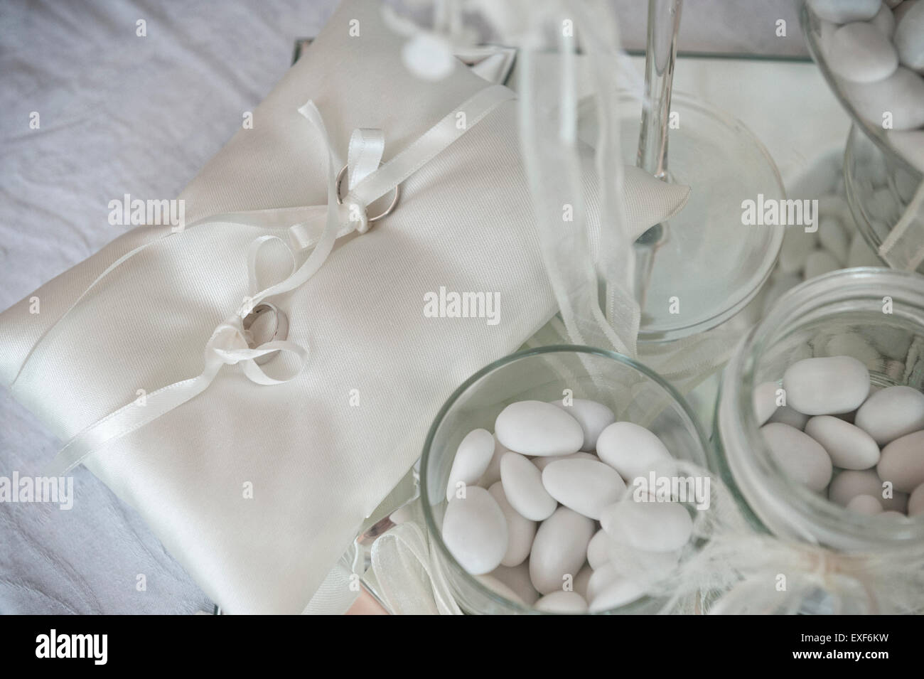 Paire de bagues de mariage sur petit coussin et blanc confetti Banque D'Images