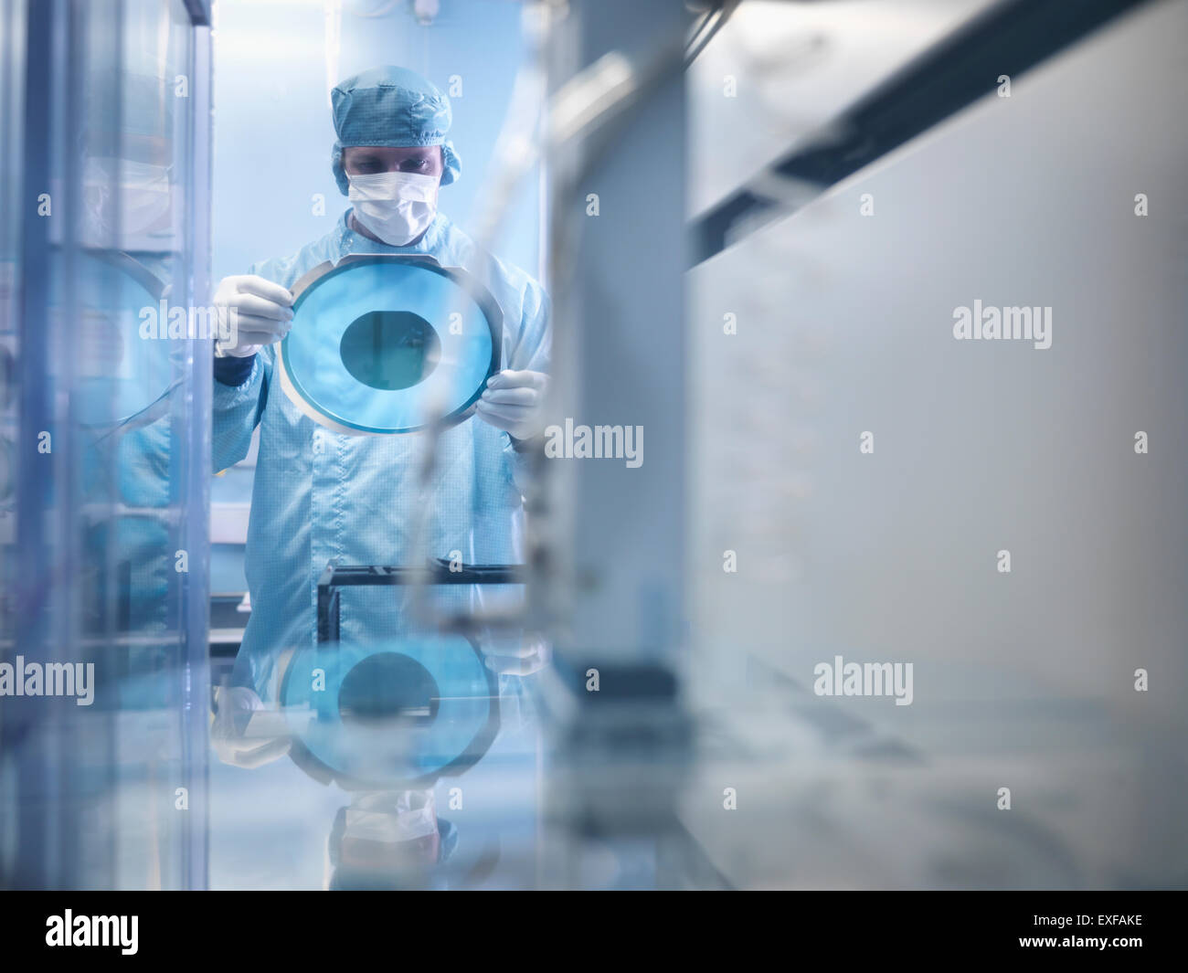 Electronics worker holding plaquette de silicium par machine de coupe en salle blanche Banque D'Images