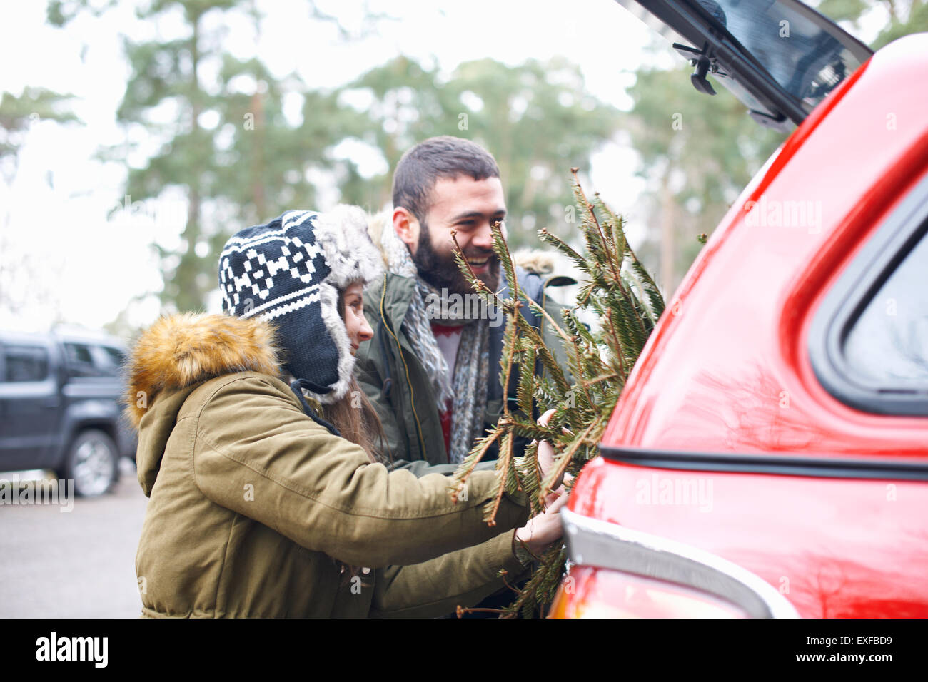 Jeune couple avec arbre de Noël en démarrage auto Banque D'Images