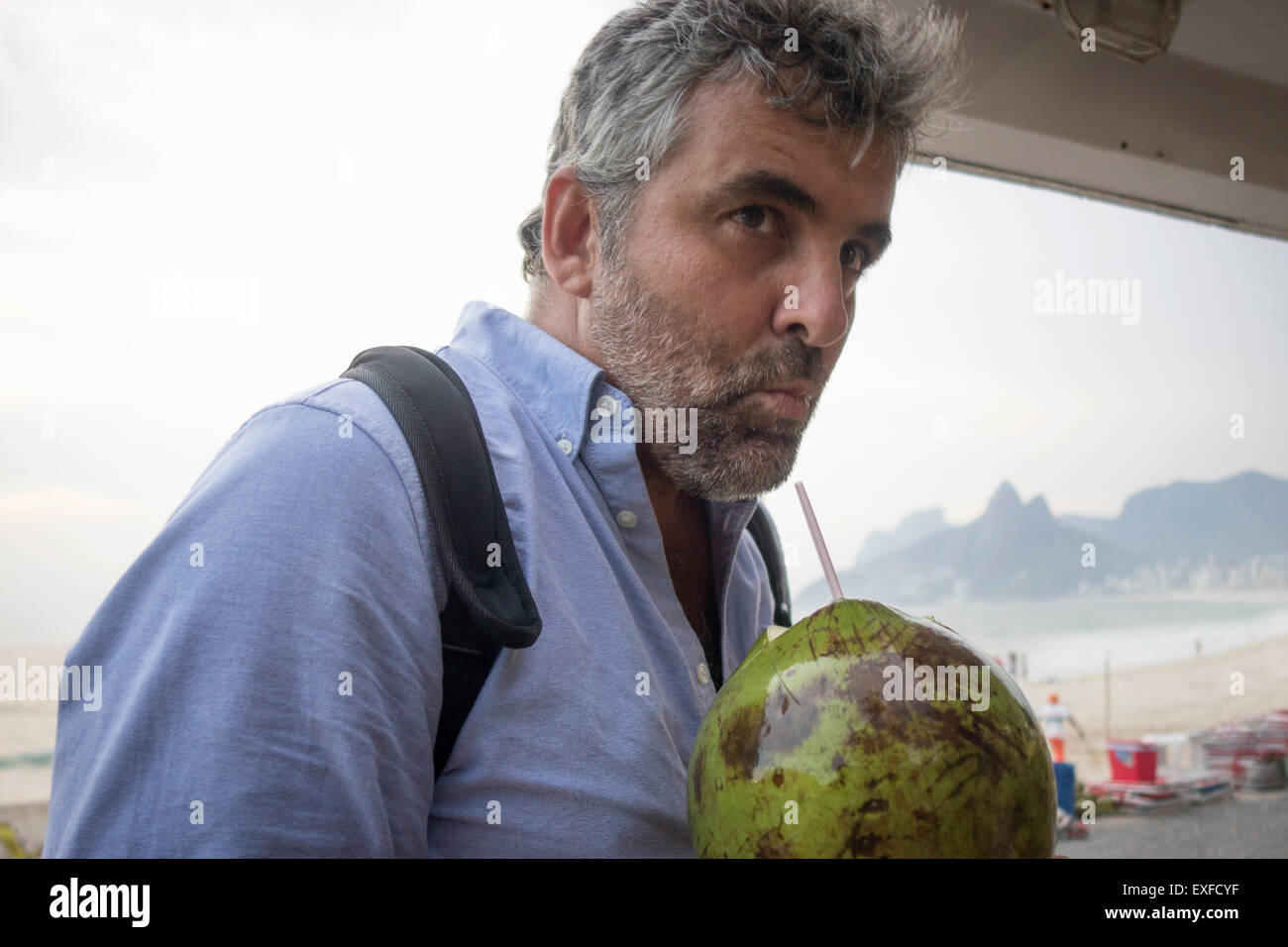 L'homme de boire du jus de noix de coco fraîche, Ipanema Beach, Rio de Janeiro, Brésil Banque D'Images