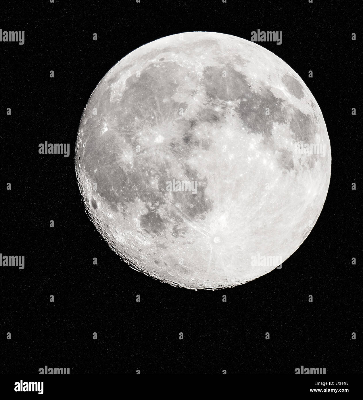 Pleine lune moins quelques heures avec un cratère Ragged Edge et bordée d'étoiles derrière mouchetée - photographié au Royaume-Uni Banque D'Images