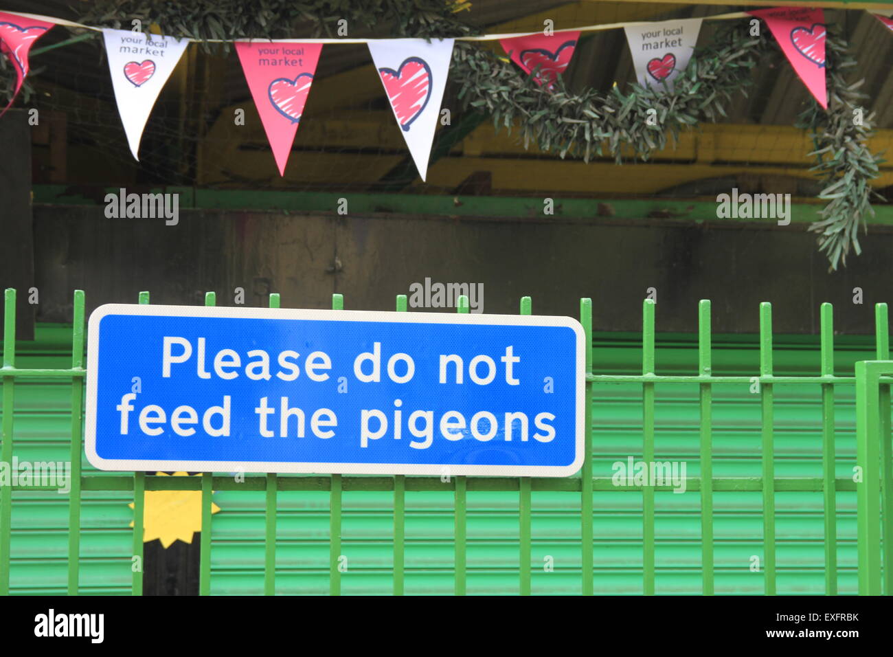 Veuillez ne pas nourrir les pigeons - signe d'humour au marché de Peterborough avec coeur noir. Vert et Bleu. Banque D'Images